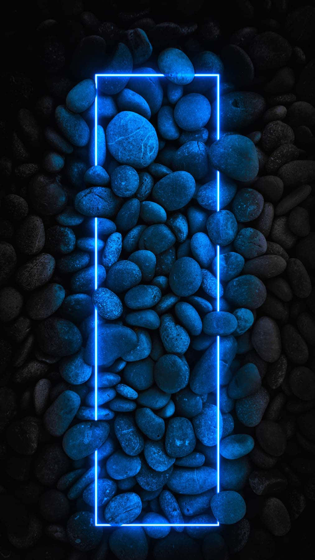 Blue Neon Lights 桌布 壁紙 — 發光的藍色霓虹燈矩形框住光滑的石頭，背景是深色鵝卵石。