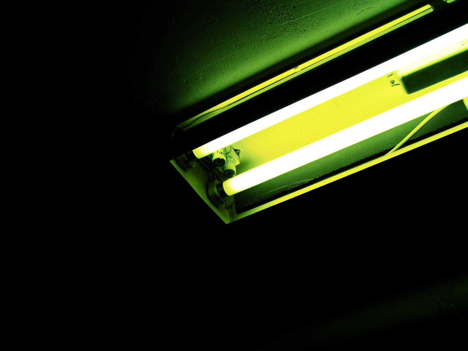 Light 桌布 壁紙 — 發光的螢光燈管在黑暗的天花板上投射出強烈的綠黃色光芒，營造出簡約而嚴肅的環境。