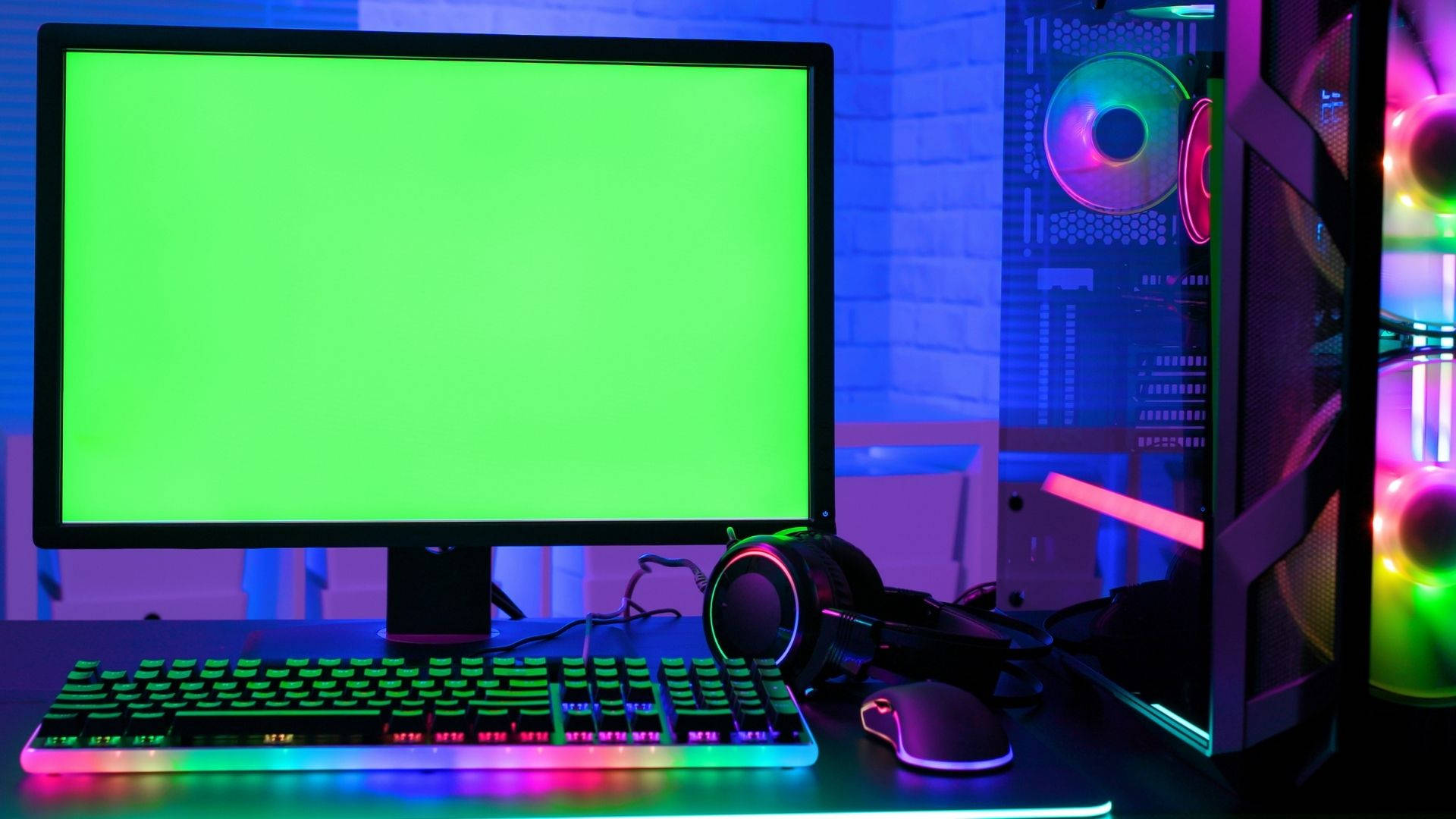 Green Screen 桌布 壁紙 — 發光的遊戲設置，配備綠色螢幕、RGB 鍵盤和一個浸沒在霓虹燈光中的透明機殼 PC。