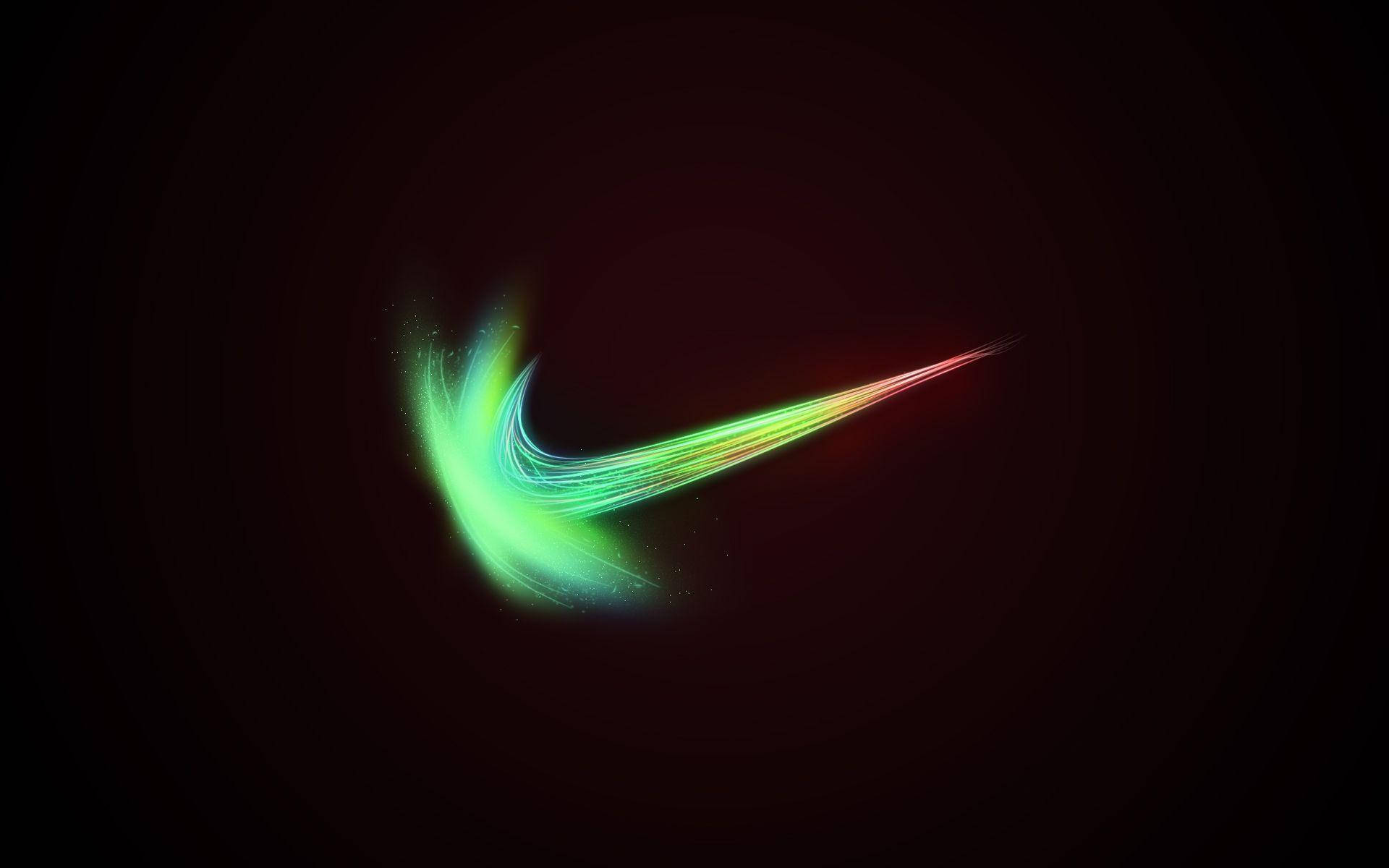 酷炫耐吉 桌布 壁紙 — 發光的霓虹Nike勾號在深色背景上劃過，帶有鮮豔的綠色、黃色和紅色色調。