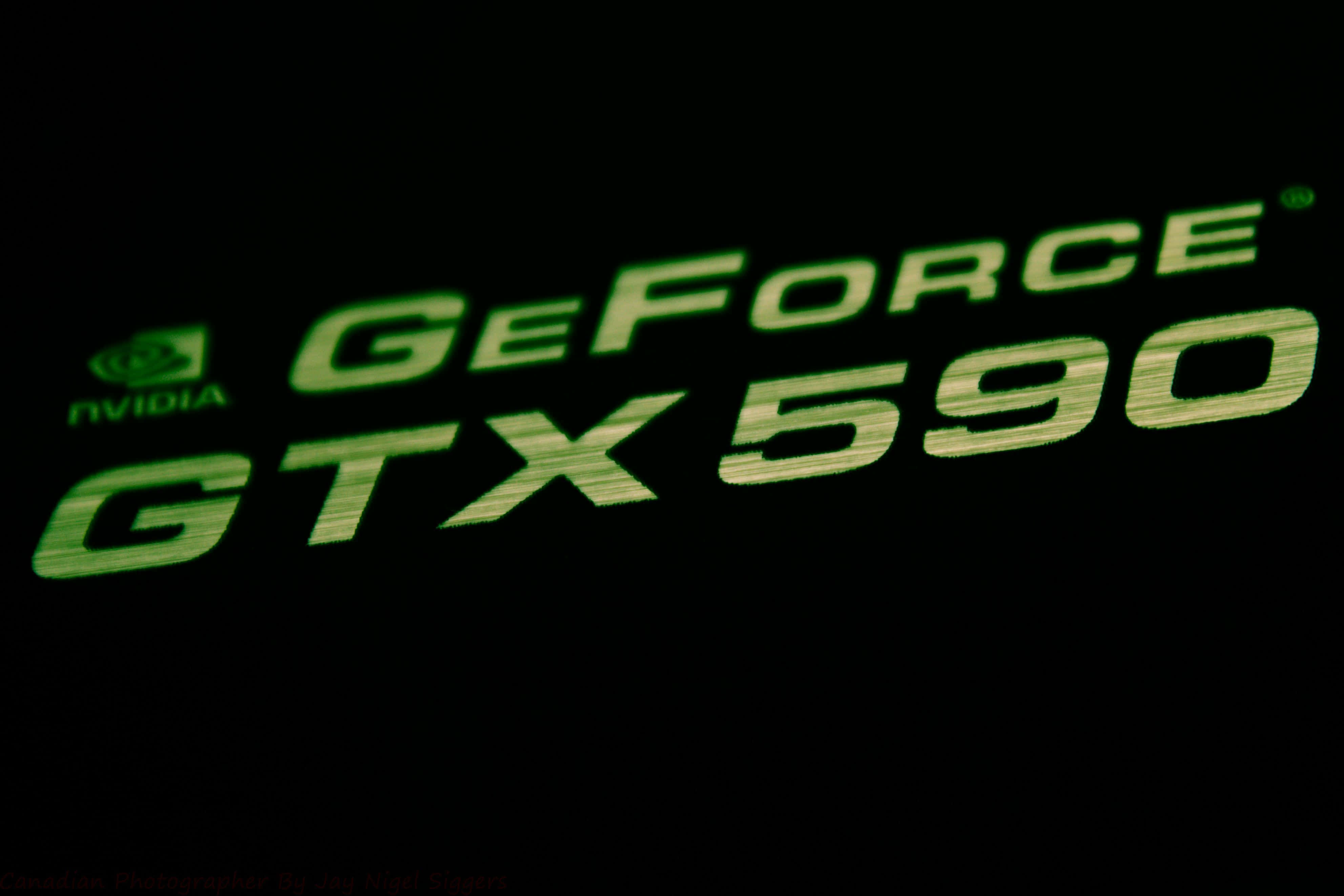 Nvidia 4K UHD 桌布 壁紙 — 發光綠色NVIDIA GeForce GTX 590標誌，在漆黑背景上亮起。