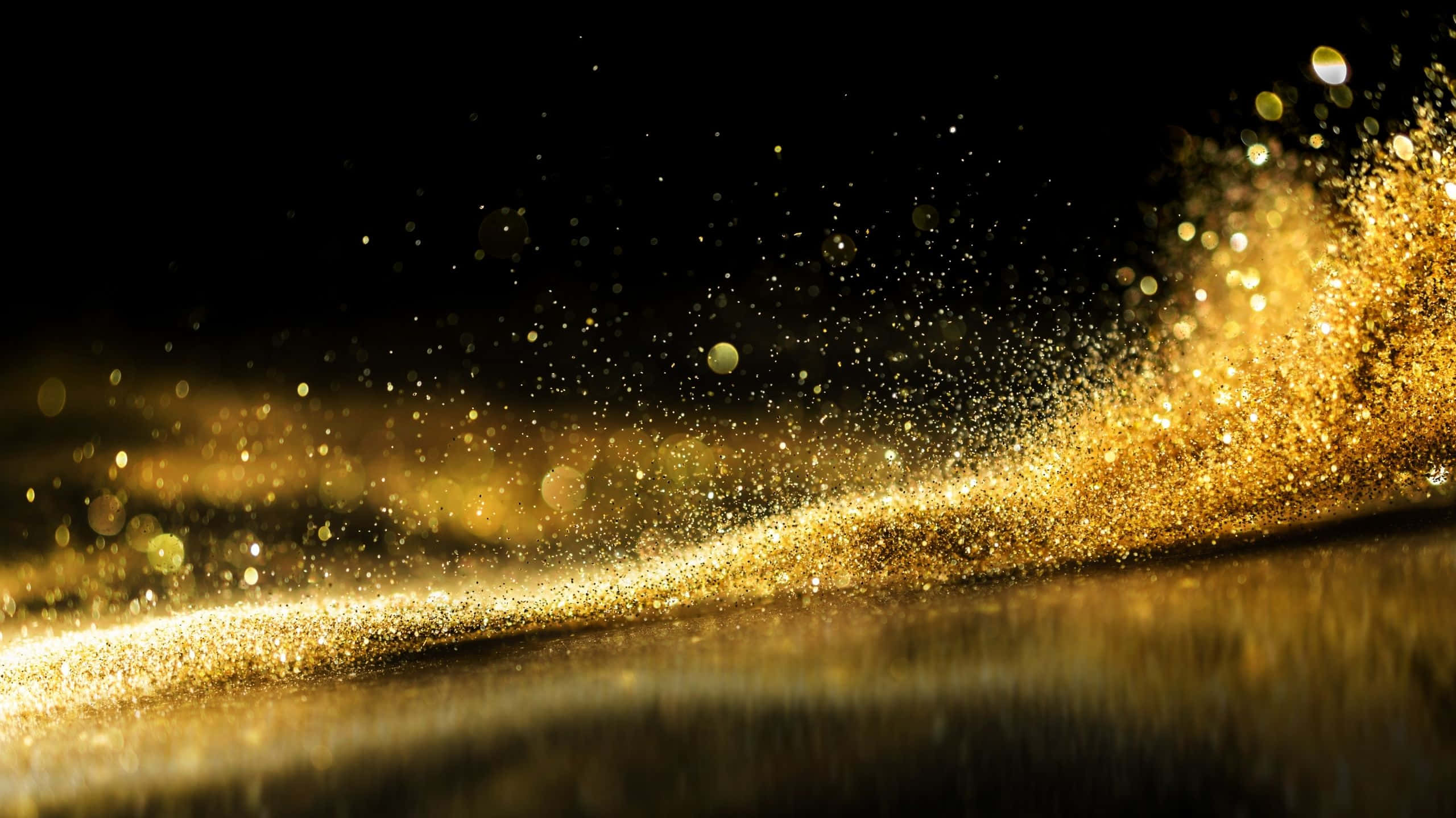 Black And Gold Glitter 桌布 壁紙 — 發光金色粒子的動態瀑布流過黑暗表面，產生燦爛閃爍效果。