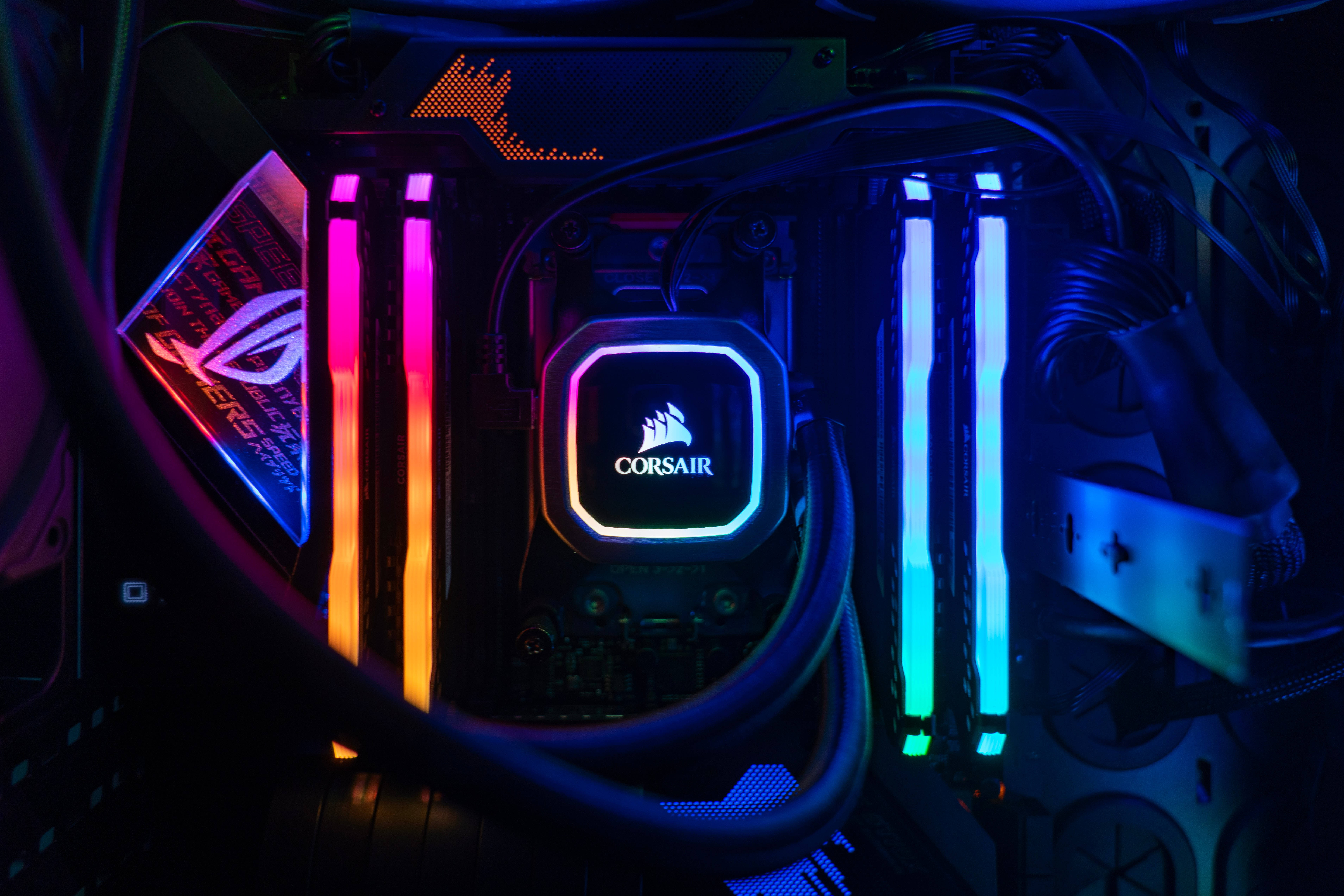 霓虹 桌布 壁紙 — 發光電腦機箱內部的特寫，帶有鮮豔的 RGB 燈光以及可見的 Corsair 和 ASUS ROG 組件。