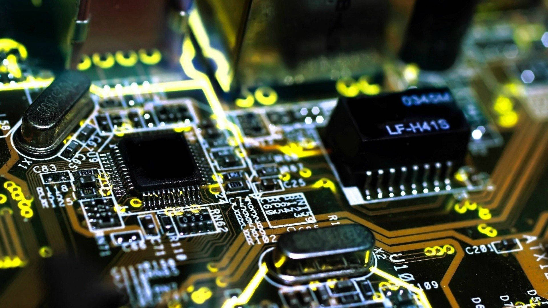 Circuit 桌布 壁紙 — 發光黃色電路板的特寫，帶有複雜的路徑和標籤的電子元件。