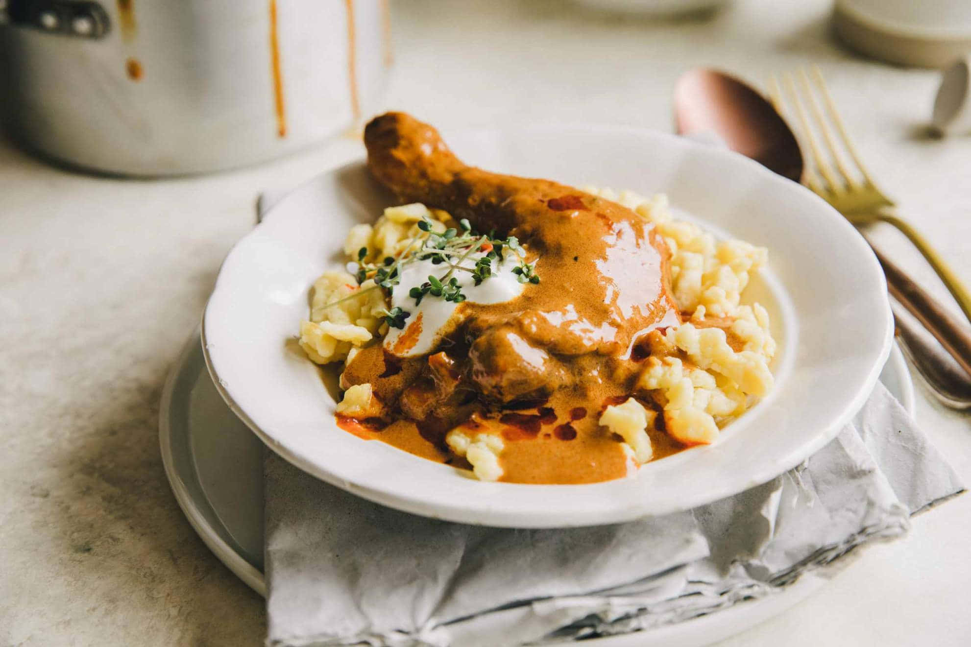 Chicken 桌布 壁紙 — 白盤上，奶油雞腿搭配濃郁醬汁，置於鬆軟馬鈴薯泥上，以新鮮香草裝飾。