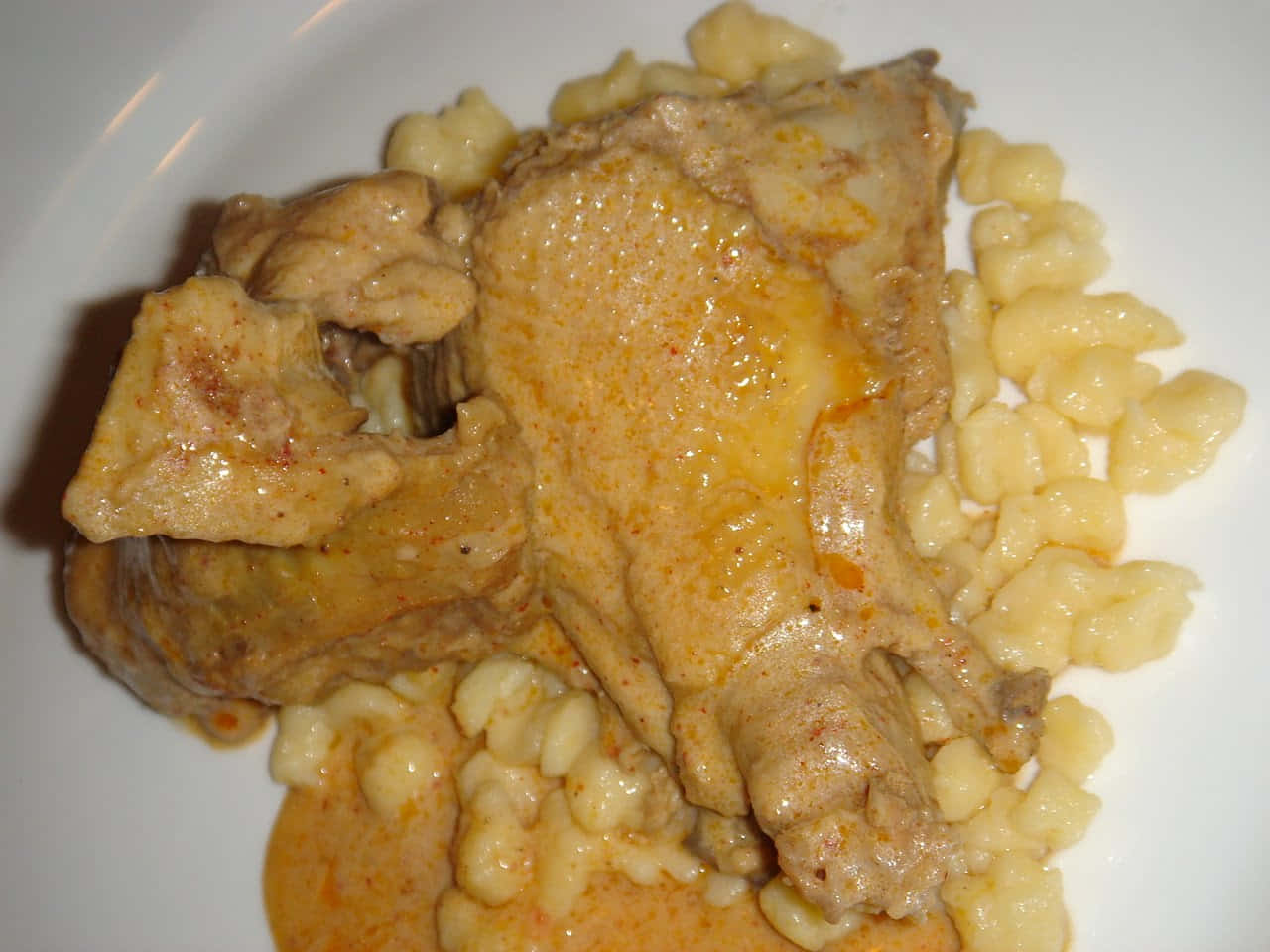Chicken 桌布 壁紙 — 白盤上嫩雞肉搭配奶油醬汁及珍珠形狀的德式麵疙瘩的特寫。