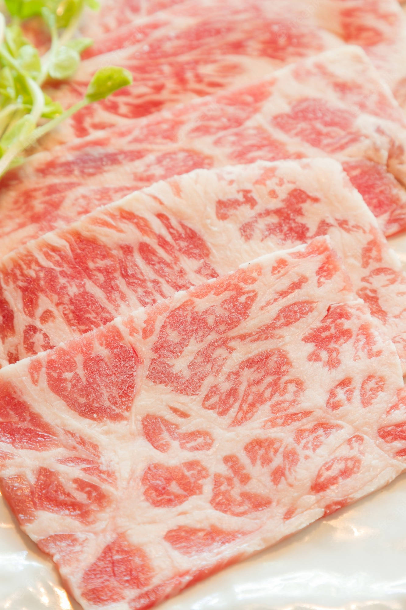 meat 桌布 壁紙 — 白盤上的大理石紋牛肉片，帶有複雜的脂肪紋理和新鮮蔬菜。
