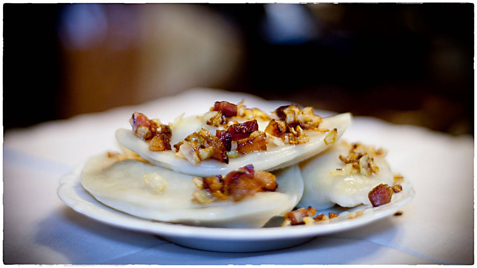 Food Photography 桌布 壁紙 — 白盤上蒸餃子配脆培根和堅果的特寫。