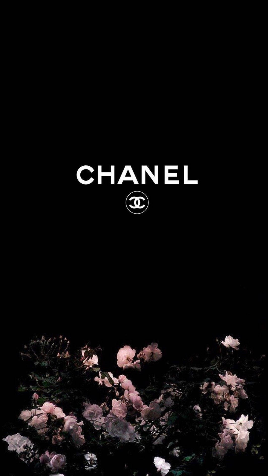 桌布 壁紙 — 白色 Chanel 標誌漂浮在精緻的粉紅玫瑰上方，背景為純黑色。