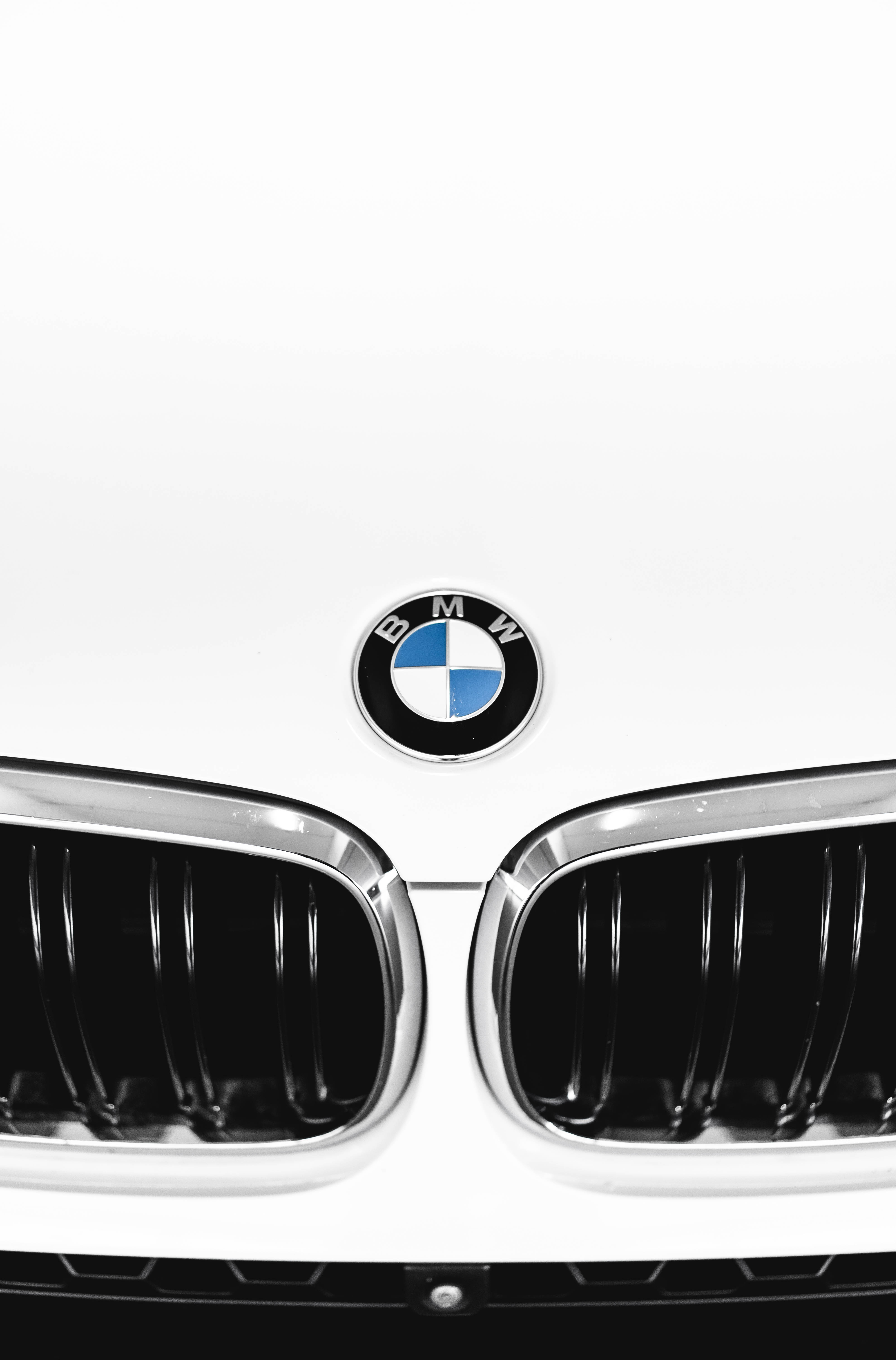 m 桌布 壁紙 — 白色BMW汽車前格柵和標誌性圓形標誌的特寫，背景簡潔極簡。