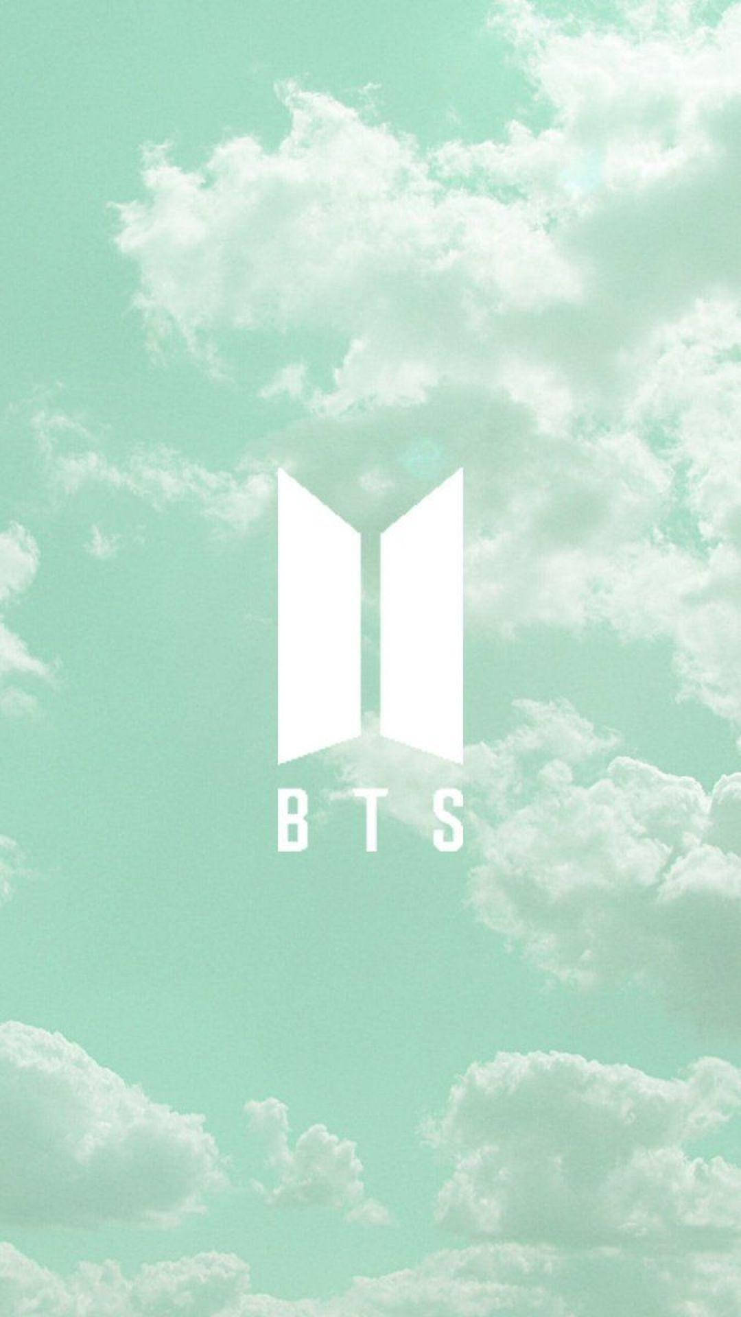 BTS 桌布 壁紙 — 白色BTS標誌漂浮在柔和的薄荷綠色天空上，天空充滿蓬鬆的白雲。