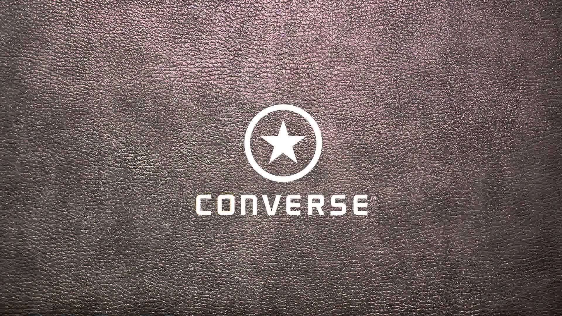 Converse 標誌 桌布 壁紙 — 白色Converse標誌搭配星形徽章，居中於紋理深棕色皮革背景上。