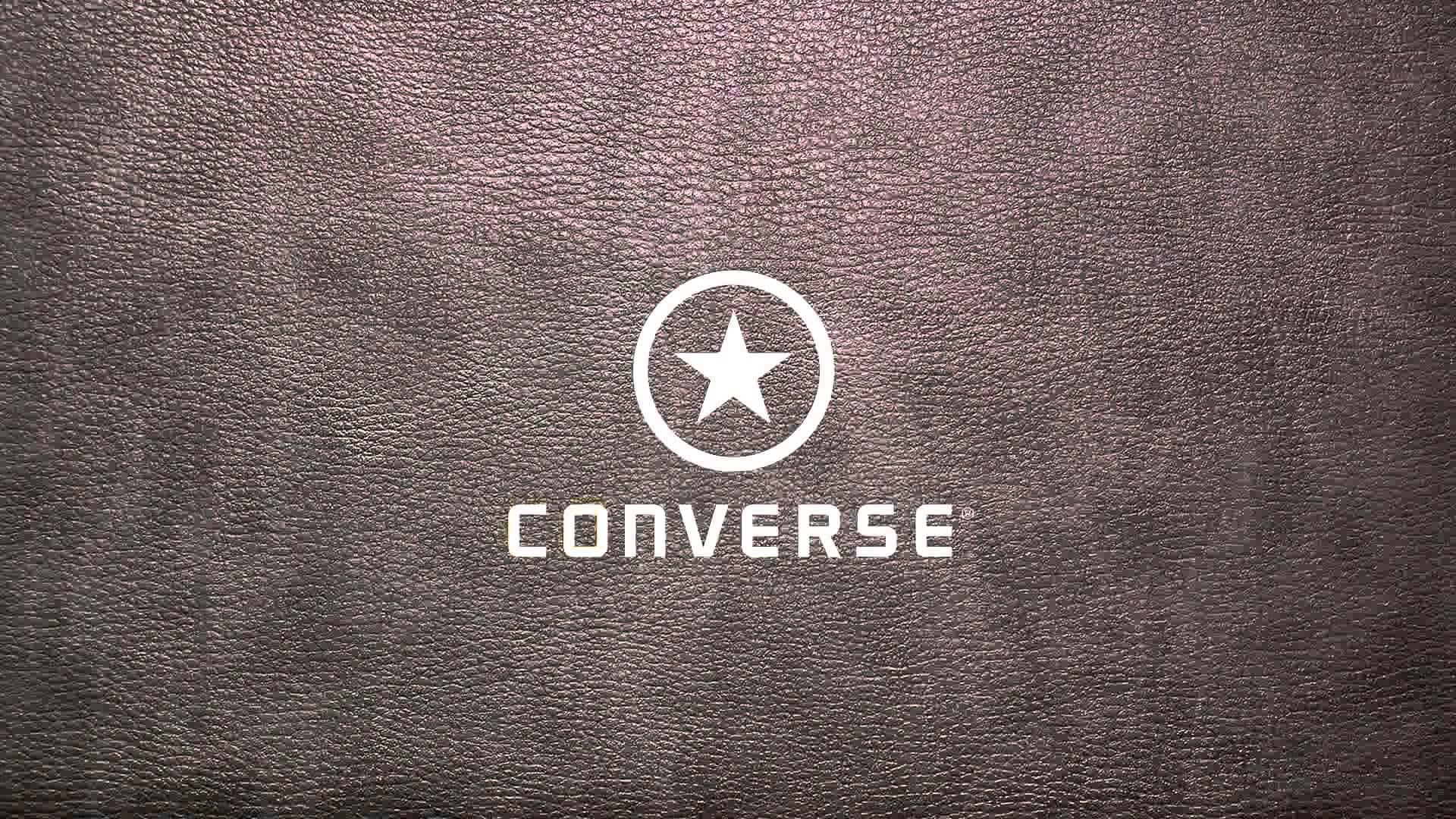 Converse Logo 桌布 壁紙 — 白色Converse標誌搭配星形徽章，居中於有紋理的深棕色皮革背景上。