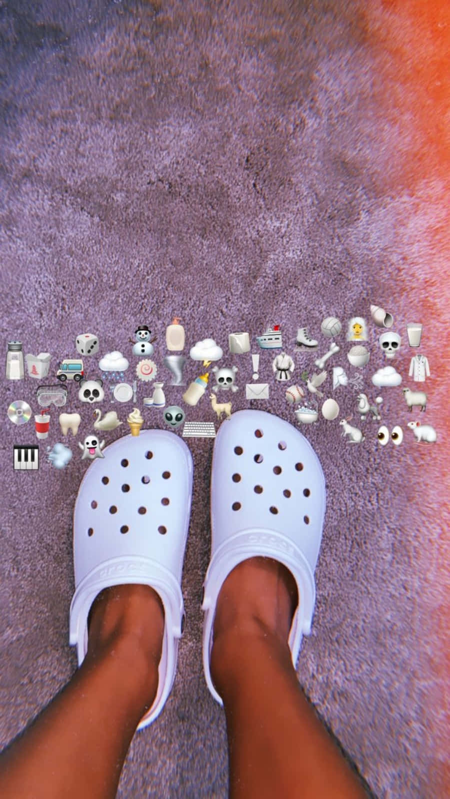 Crocs 桌布 壁紙 — 白色Crocs放在紫色地毯上，周圍環繞著色彩繽紛的表情符號貼紙。
