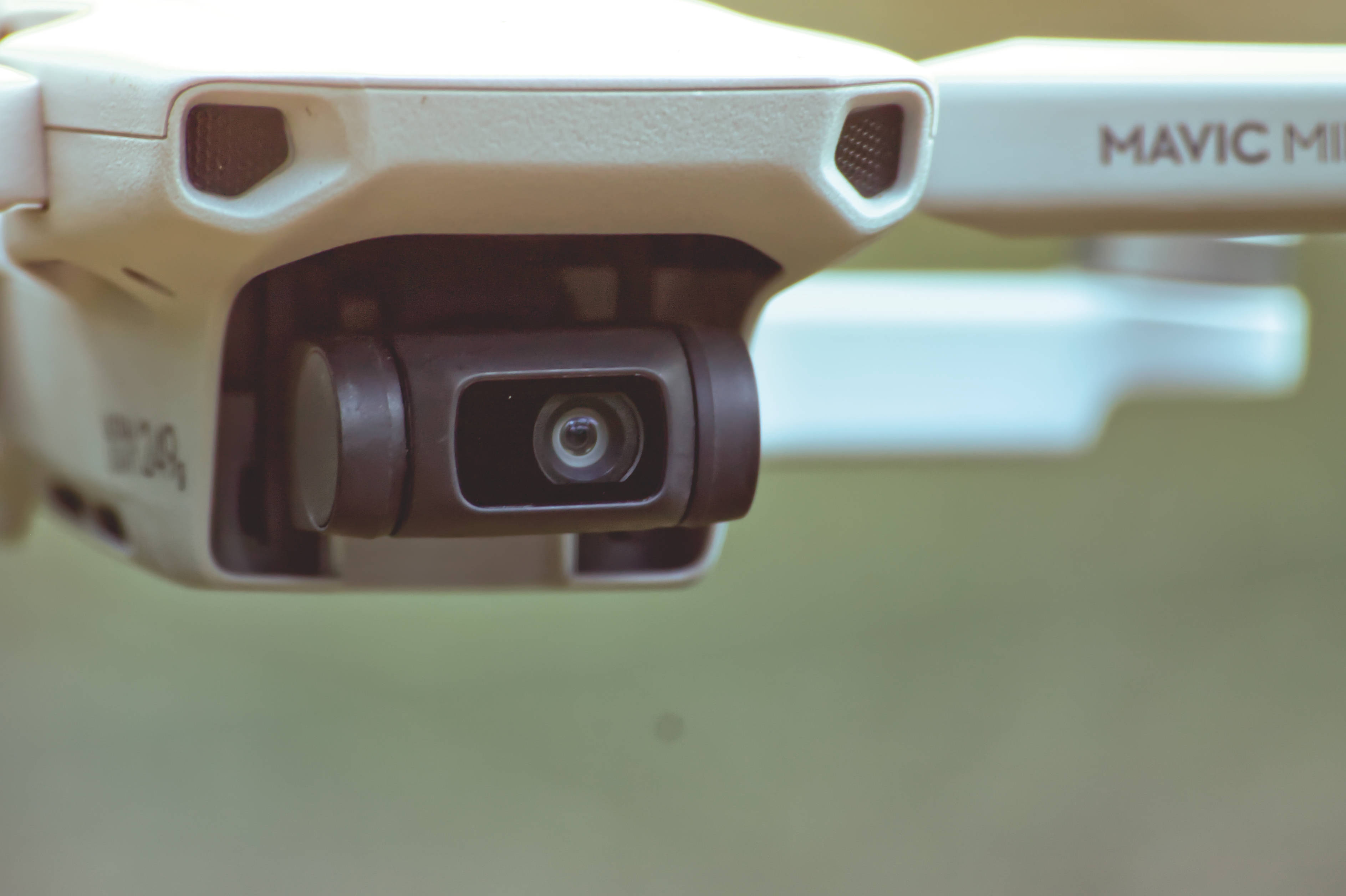 網路攝影機 桌布 壁紙 — 白色DJI Mavic Mini無人機相機鏡頭特寫，背景柔和模糊。