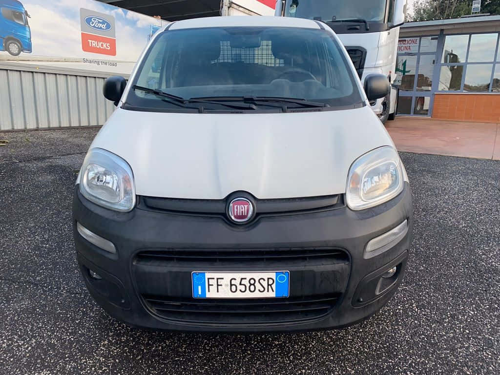 Fiat Panda 桌布 壁紙 — 白色Fiat Panda正面視圖，停放在福特卡車經銷商大樓附近的柏油路上。