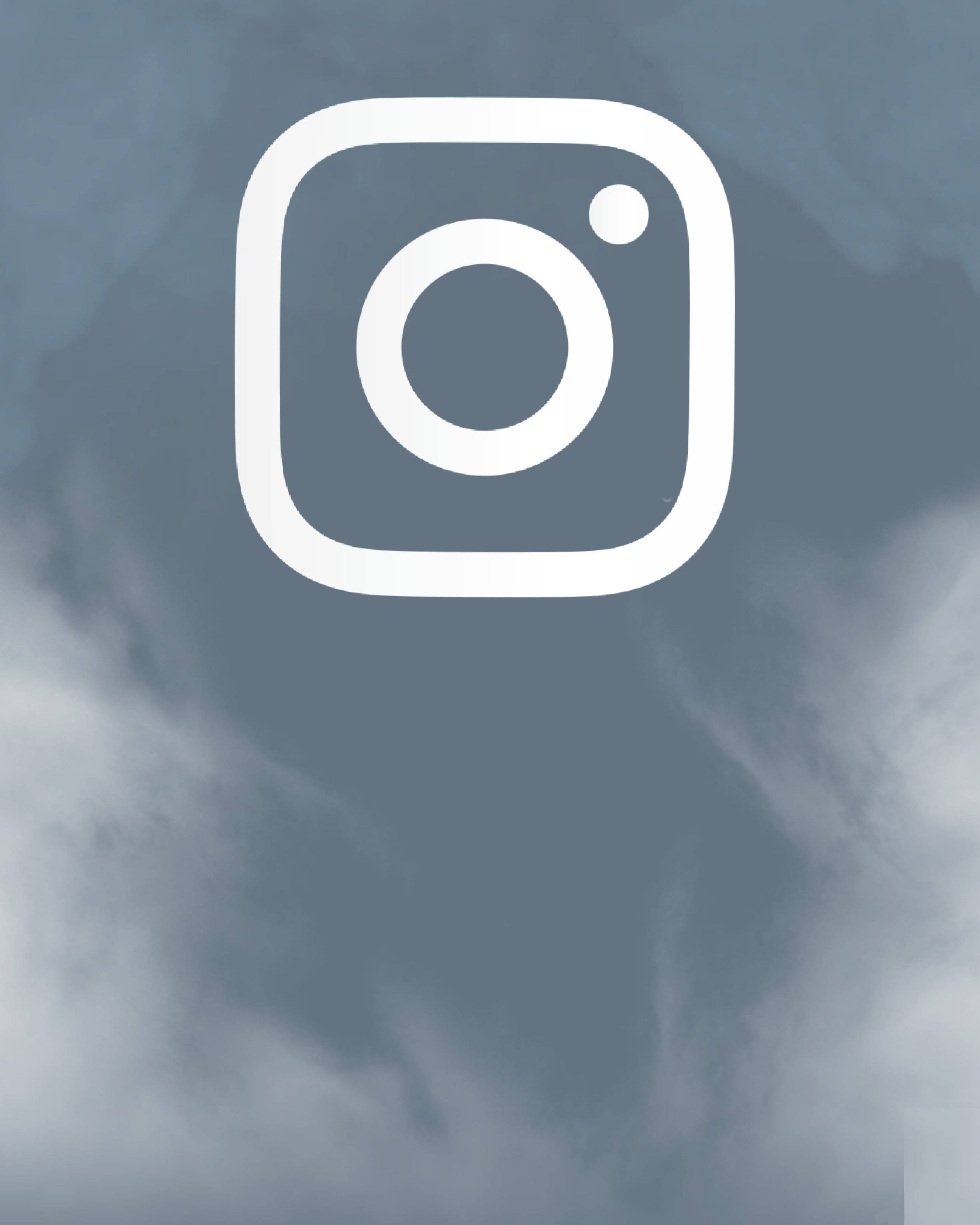 Instagram 桌布 壁紙 — 白色Instagram標誌置中於柔和灰藍色多雲天空背景上。