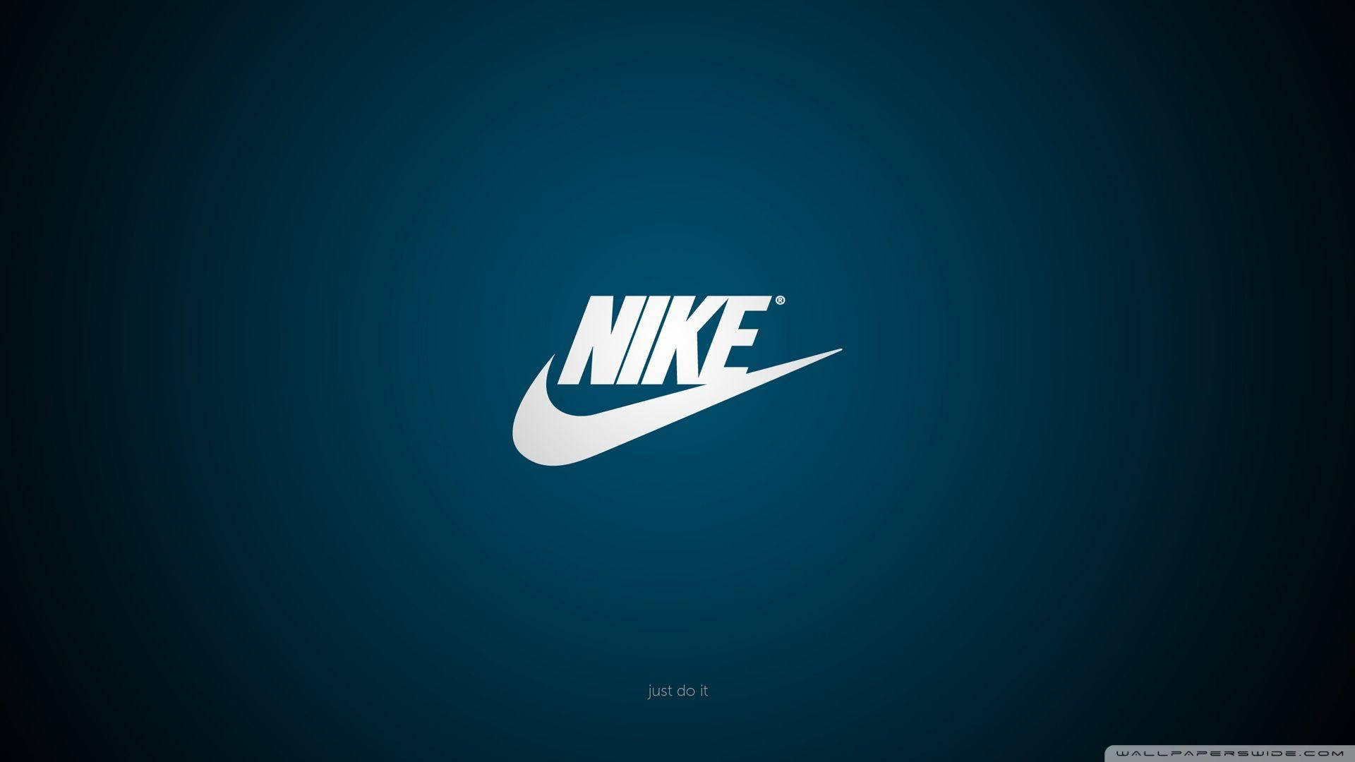 酷炫耐吉 桌布 壁紙 — 白色Nike勾號標誌居中於漸變藍色背景上，帶有微妙的徑向照明。