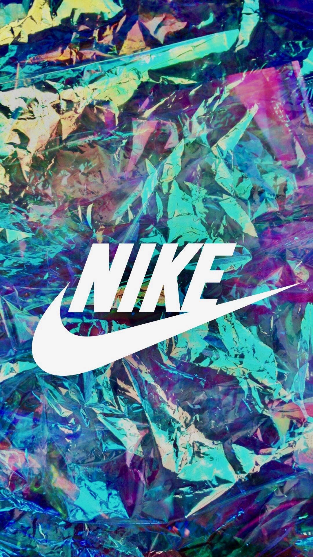 酷炫耐吉 桌布 壁紙 — 白色Nike標誌居中，置於充滿活力的皺褶全息箔背景上，帶有變化的藍色、紫色和綠色。