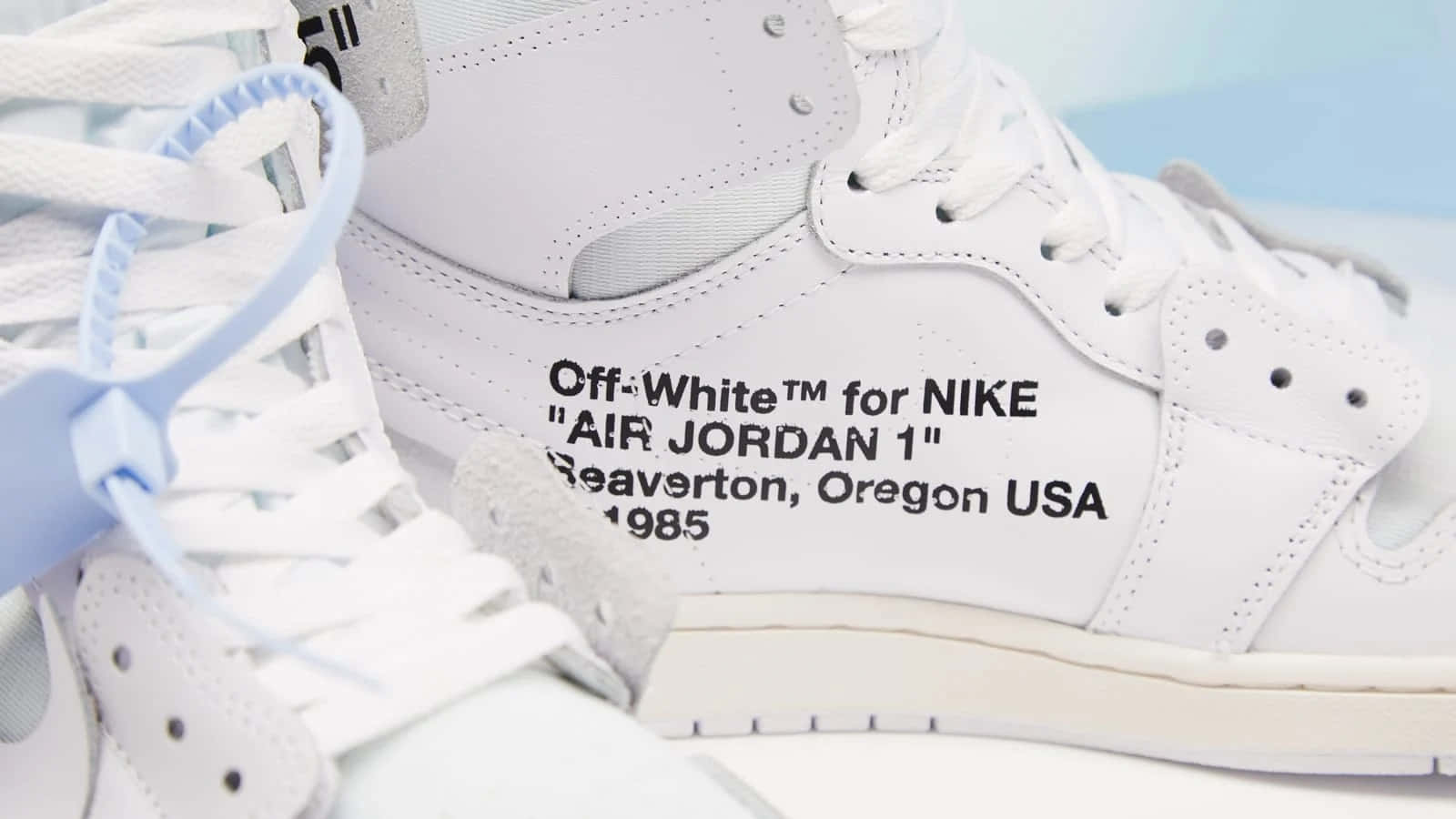 Oregon 桌布 壁紙 — 白色Off-White for Nike Air Jordan 1運動鞋特寫，搭配淺藍色鞋帶和黑色文字細節。