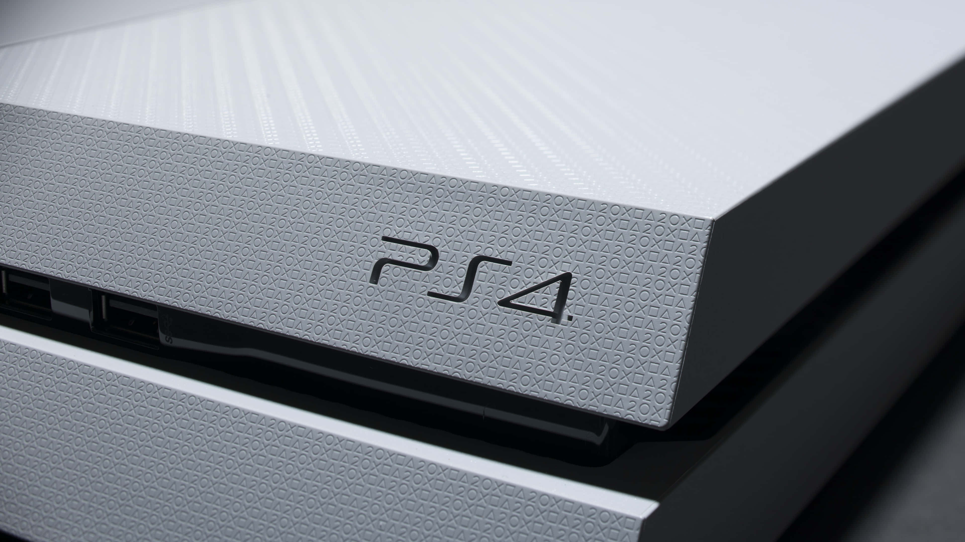 4K Gaming Consoles 桌布 壁紙 — 白色PlayStation 4主機特寫，展示紋理表面和標誌，光線乾淨。