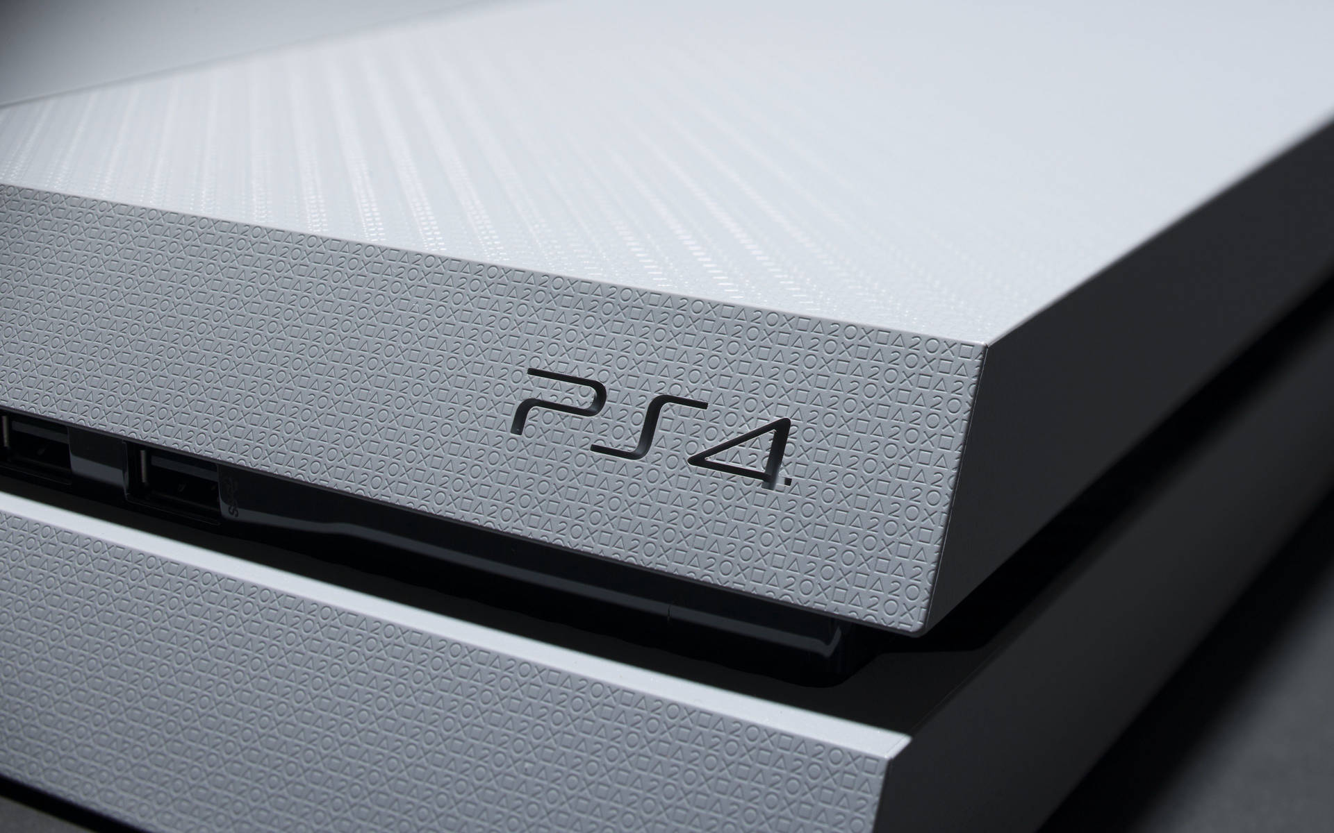 白色PS4遊戲主機，表面有紋理，黑色標誌。