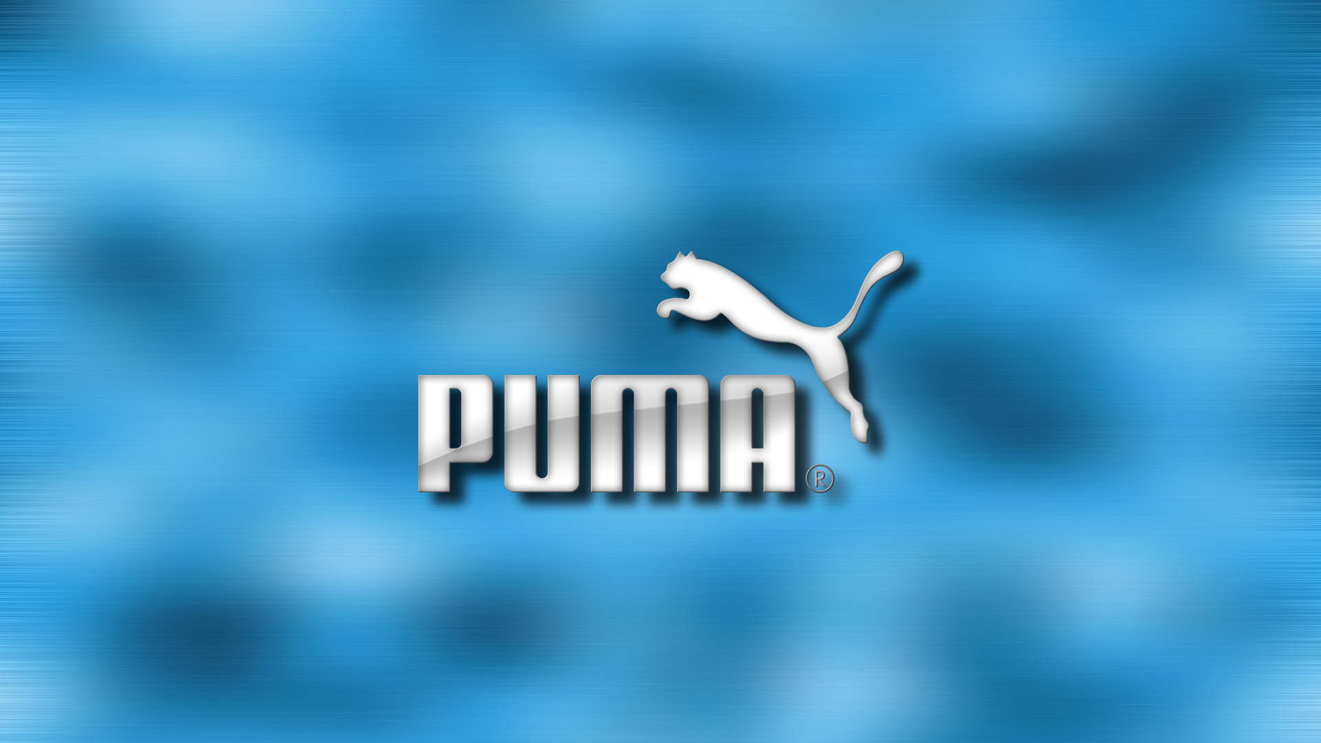 Puma 桌布 壁紙 — 白色Puma標誌，帶有跳躍的貓和粗體文字，居中在模糊的藍色漸變背景上。