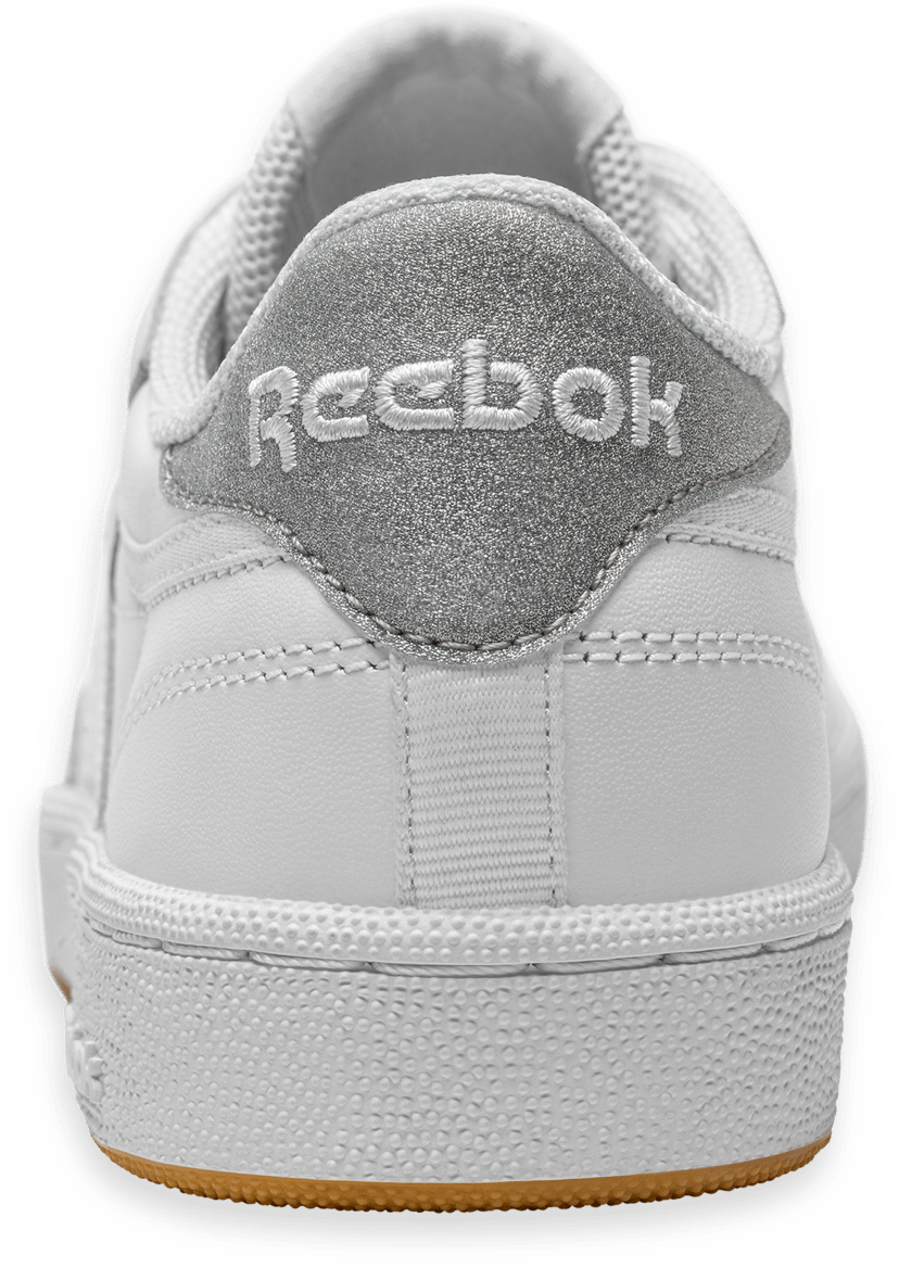 銳步 桌布 壁紙 — 白色Reebok運動鞋特寫，帶閃亮銀色後跟標籤和橡膠鞋底，背景為綠色。