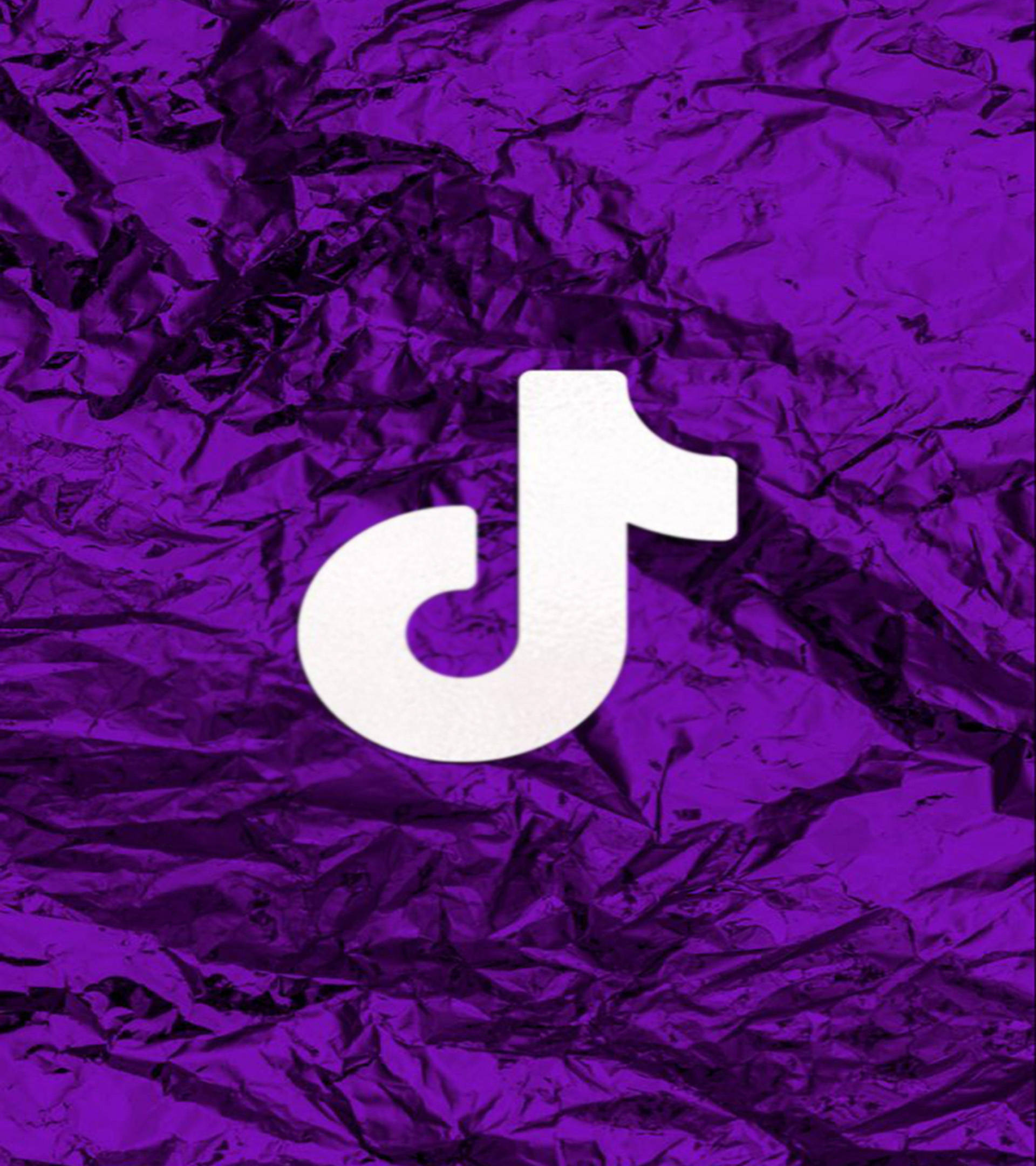 TikTok 動圖 桌布 壁紙 — 白色TikTok標誌居中於皺褶金屬紫色箔紙背景上。