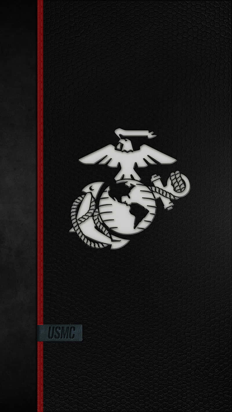 Usmc 桌布 壁紙 — 白色USMC鷹、地球、錨標誌壓印在紋理黑色皮革上，配有紅色書脊和灰色USMC標籤。
