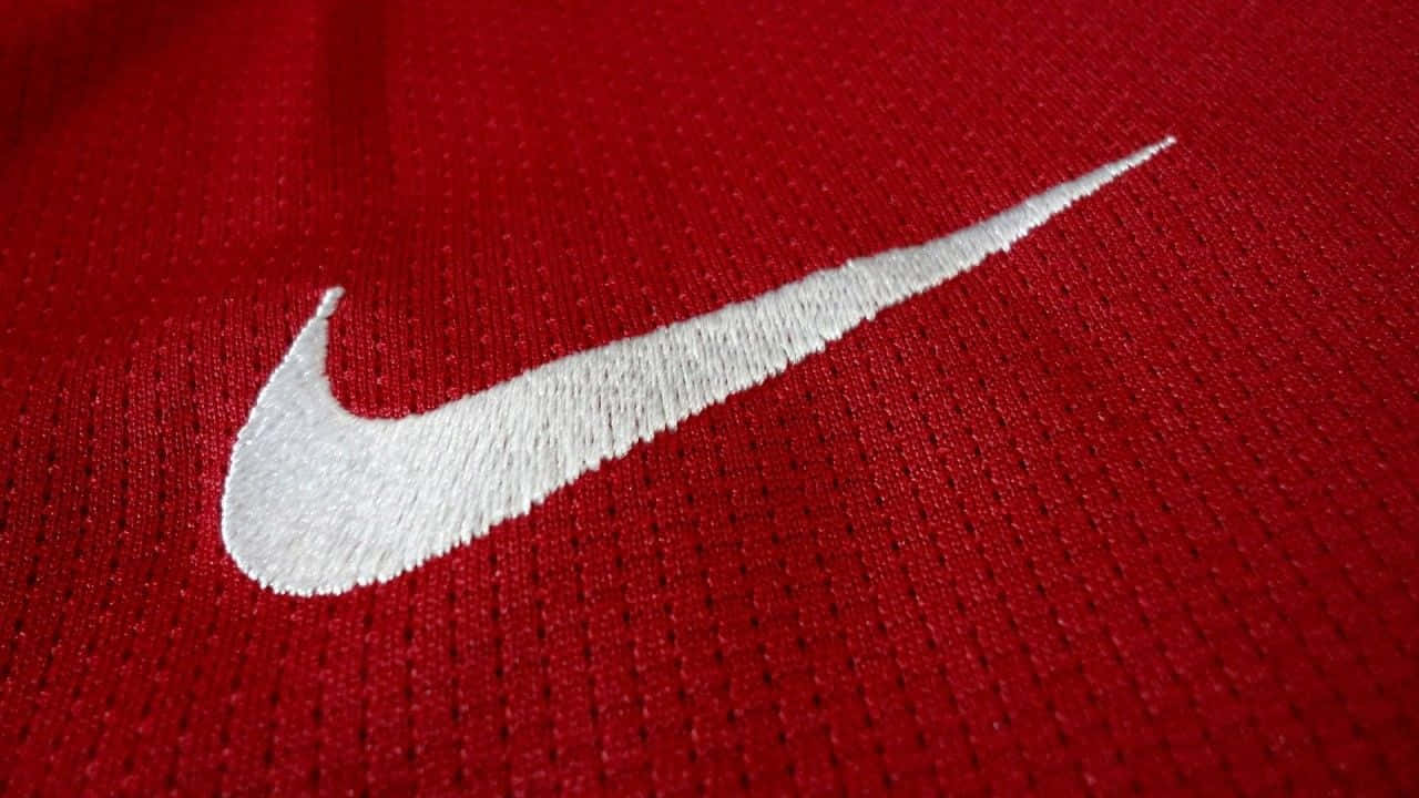 Red Nike 桌布 壁紙 — 白色刺繡Nike標誌在質感紅色運動布料上的特寫。