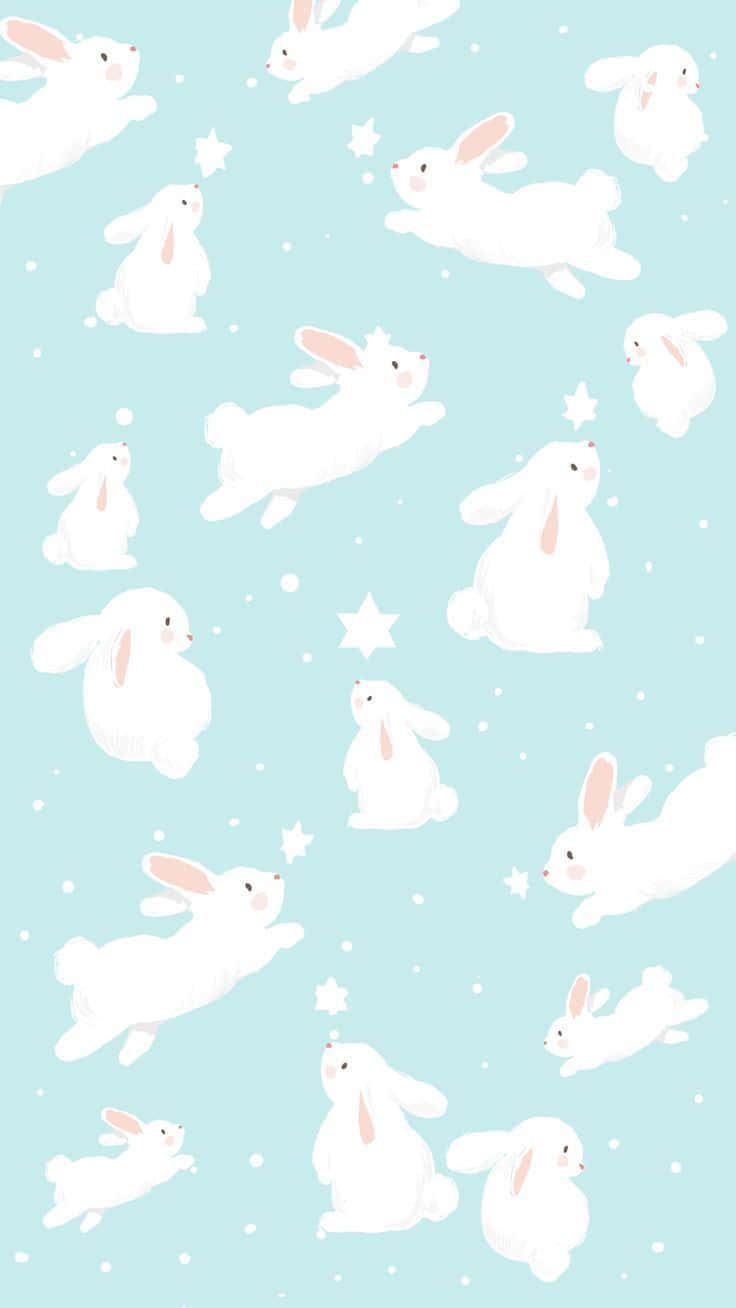 Kawaii Bunny 桌布 壁紙 — 白色卡通兔子在點綴著星星和雪花的柔和藍色背景上輕輕漂浮。