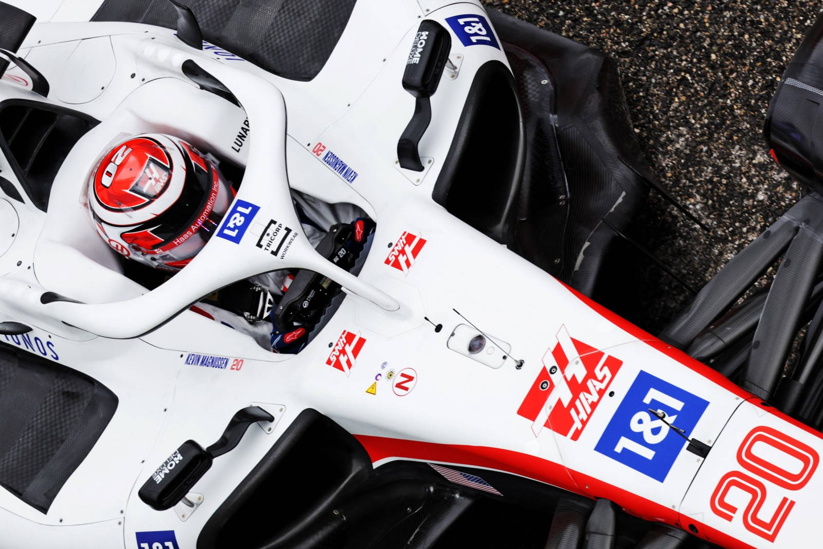 桌布 壁紙 — 白色和紅色Haas F1賽車的特寫，車手Kevin Magnussen戴著頭盔坐在駕駛艙內。