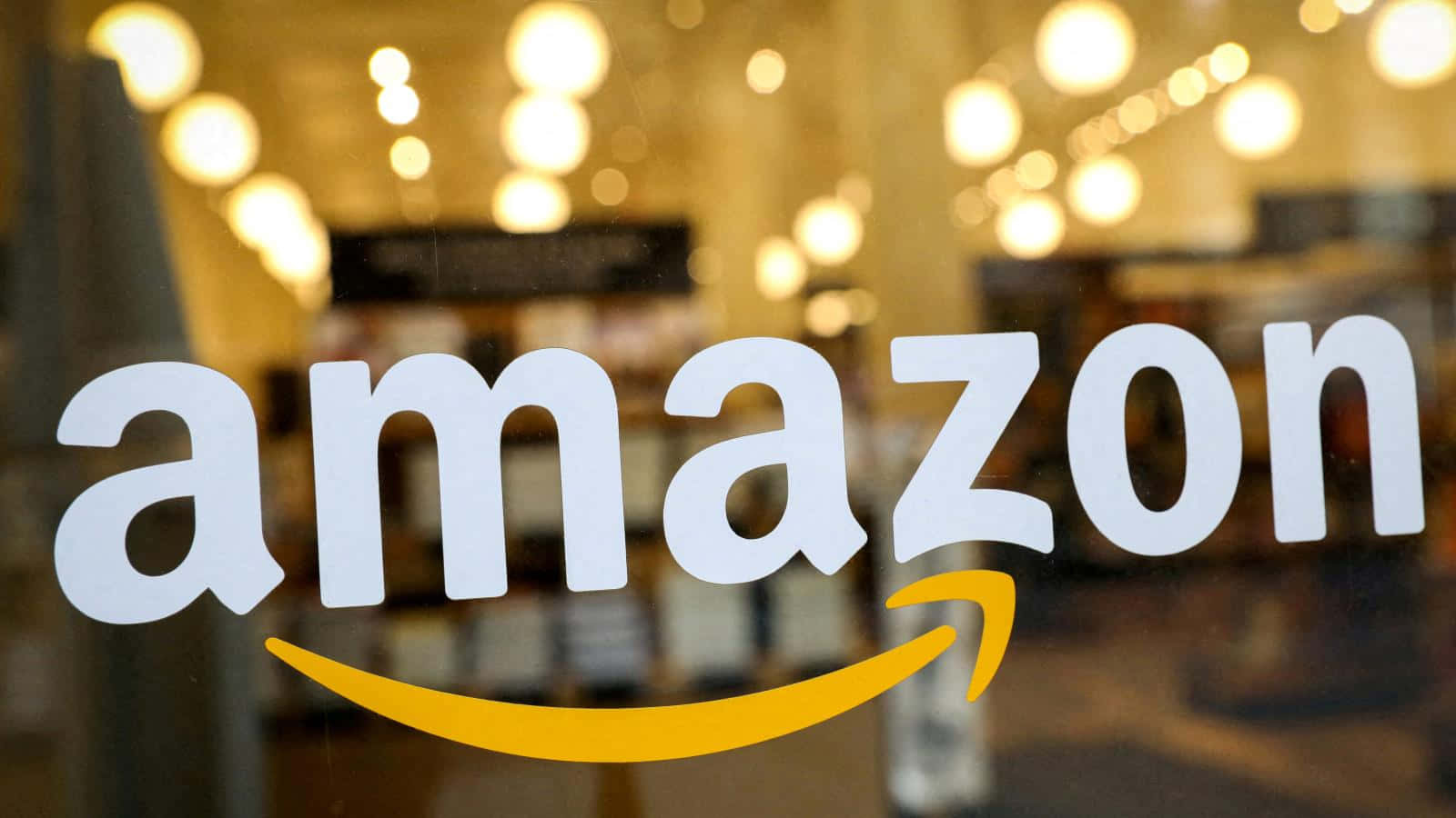 玻璃店面上的Amazon標誌，模糊的室內燈光。 — 亞馬遜 GIF 壁紙