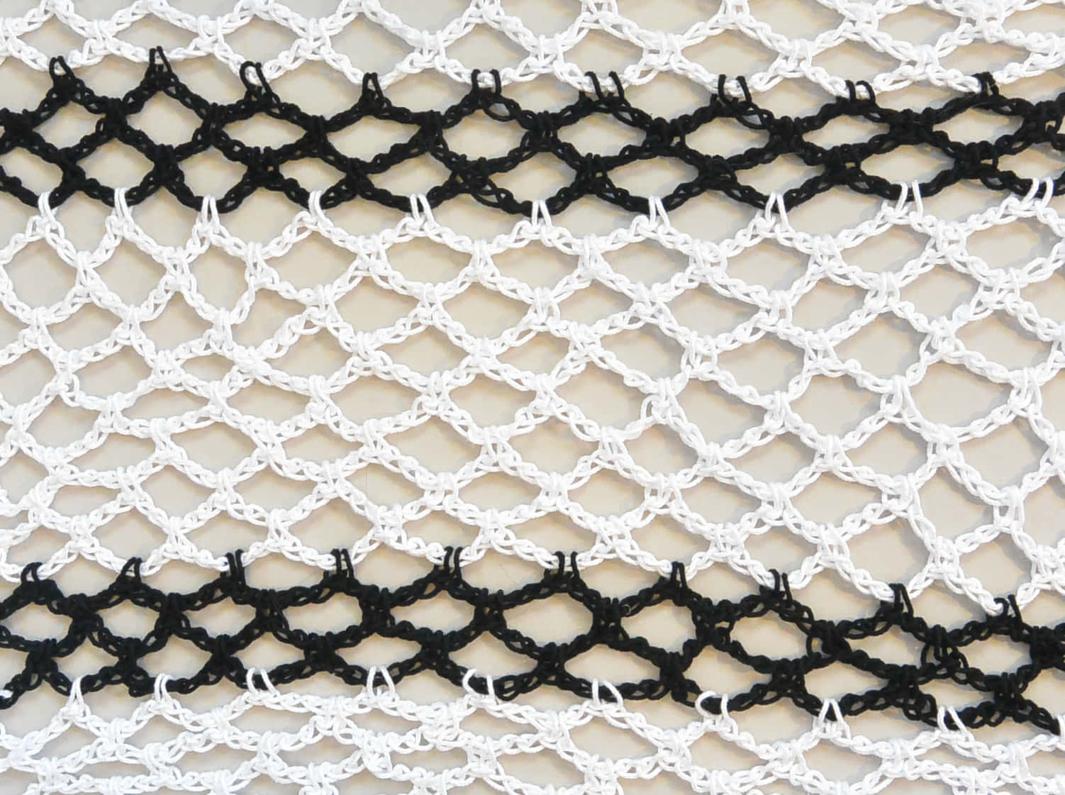 Crochet 桌布 壁紙 — 白色和黑色針織網眼布料的特寫，帶有菱形圖案和水平條紋。