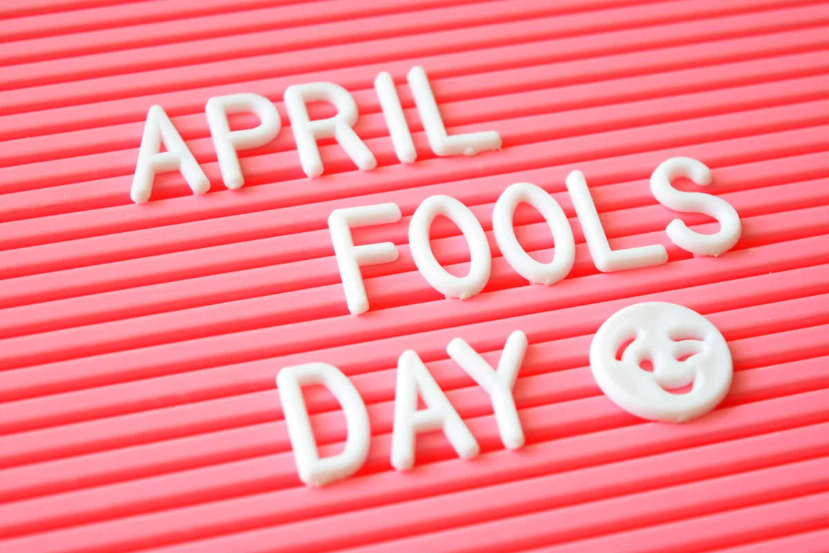Fools 桌布 壁紙 — 白色塑膠字母拼出 April Fools Day，並在亮粉紅色瓦楞板上附有笑臉。