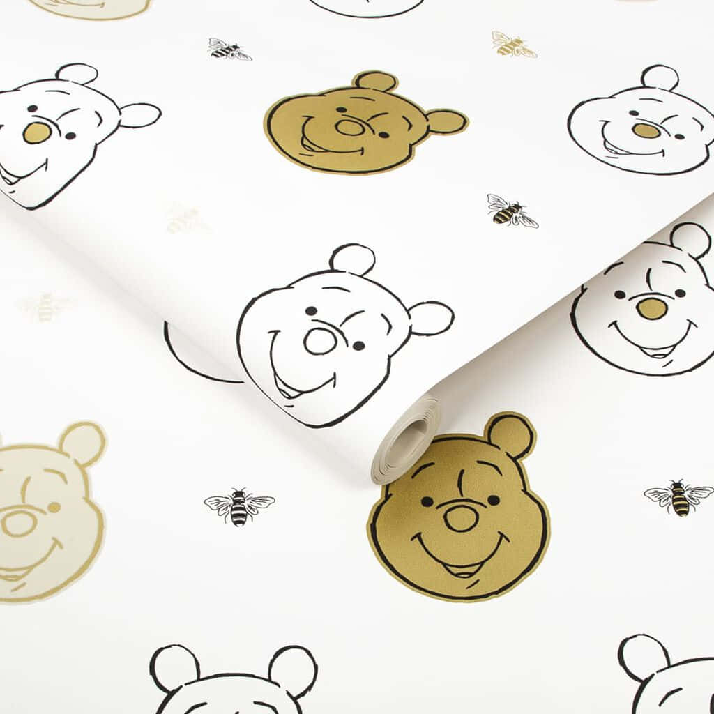 Winnie The Pooh Aesthetic 桌布 壁紙 — 白色壁紙卷，上面有重複的卡通熊臉和蜜蜂，以黑色和金色輪廓呈現。