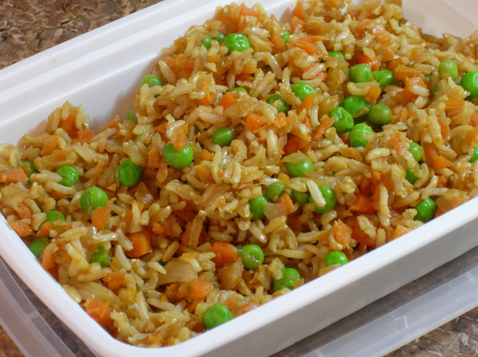 烹飪 桌布 壁紙 — 白色外帶容器中色彩鮮豔的炒飯配青豆和橙色胡蘿蔔的特寫。