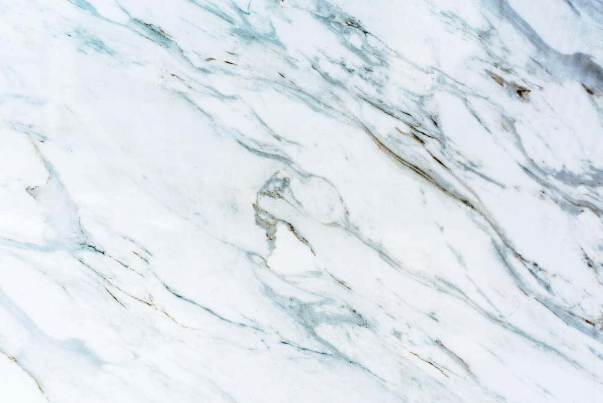 Aesthetic Marble 桌布 壁紙 — 白色大理石的近距離特寫，流動的藍色和灰色紋理營造出優雅的自然圖案。