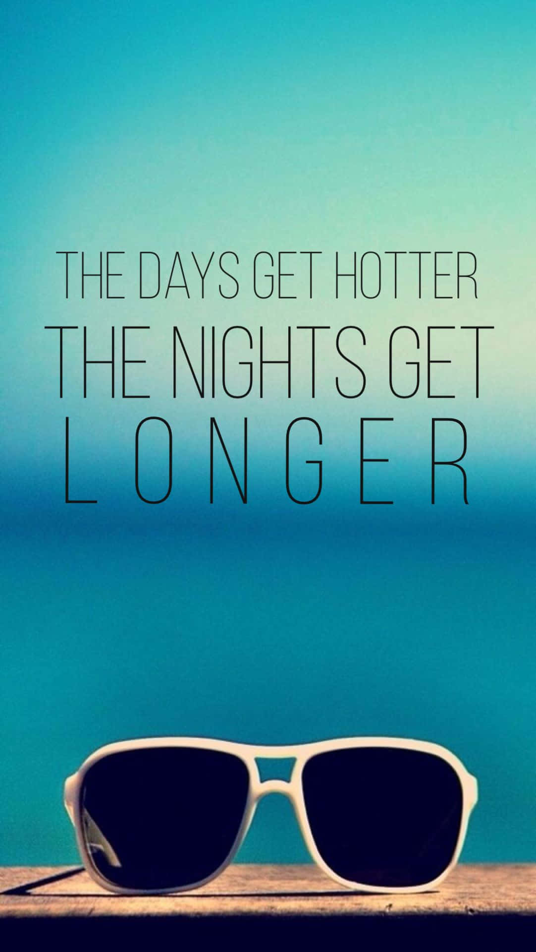 Summer Time iPhone 桌布 壁紙 — 白色太陽眼鏡放在木質表面上，背景是漸層的藍綠色天空，粗體文字寫著「白天變得更熱，夜晚變得更長」。