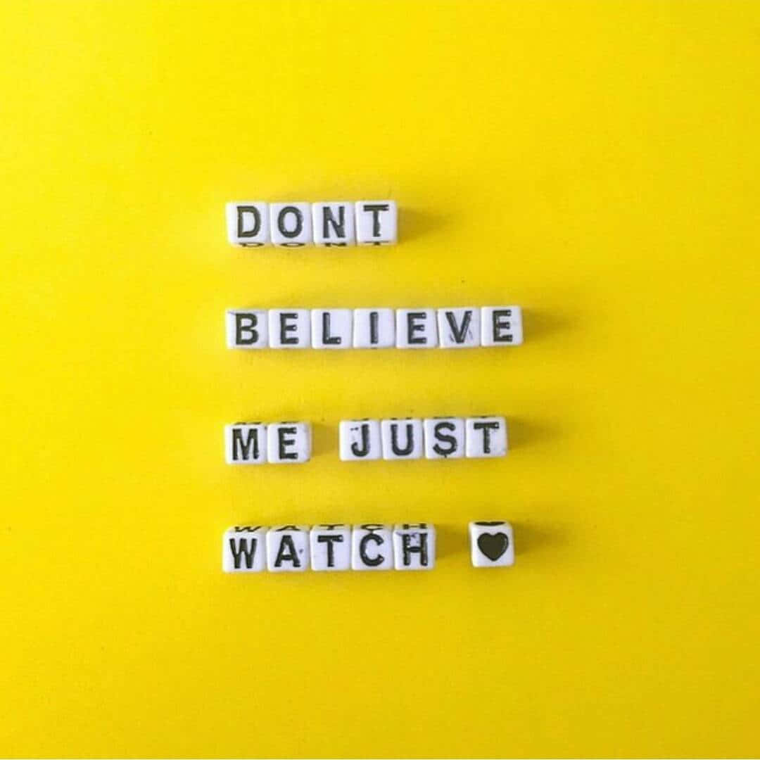 桌布 壁紙 — 白色字母瓷磚在亮黃色背景上拼出「DON'T BELIEVE ME JUST WATCH ❤️」。