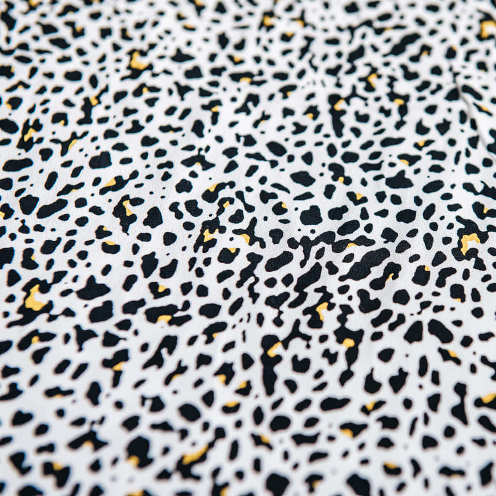 Black And White Animal Print 桌布 壁紙 — 白色布料近距離特寫，帶有類似動物圖案的黑黃斑點紋理。