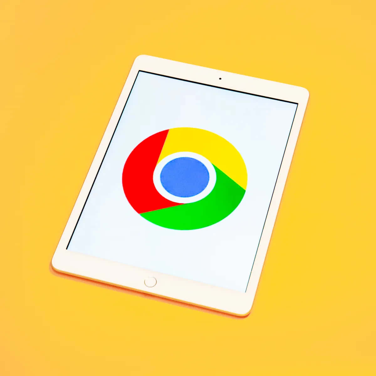 Chrome 桌布 壁紙 — 白色平板電腦在鮮黃色背景上顯示色彩繽紛的Chrome標誌。