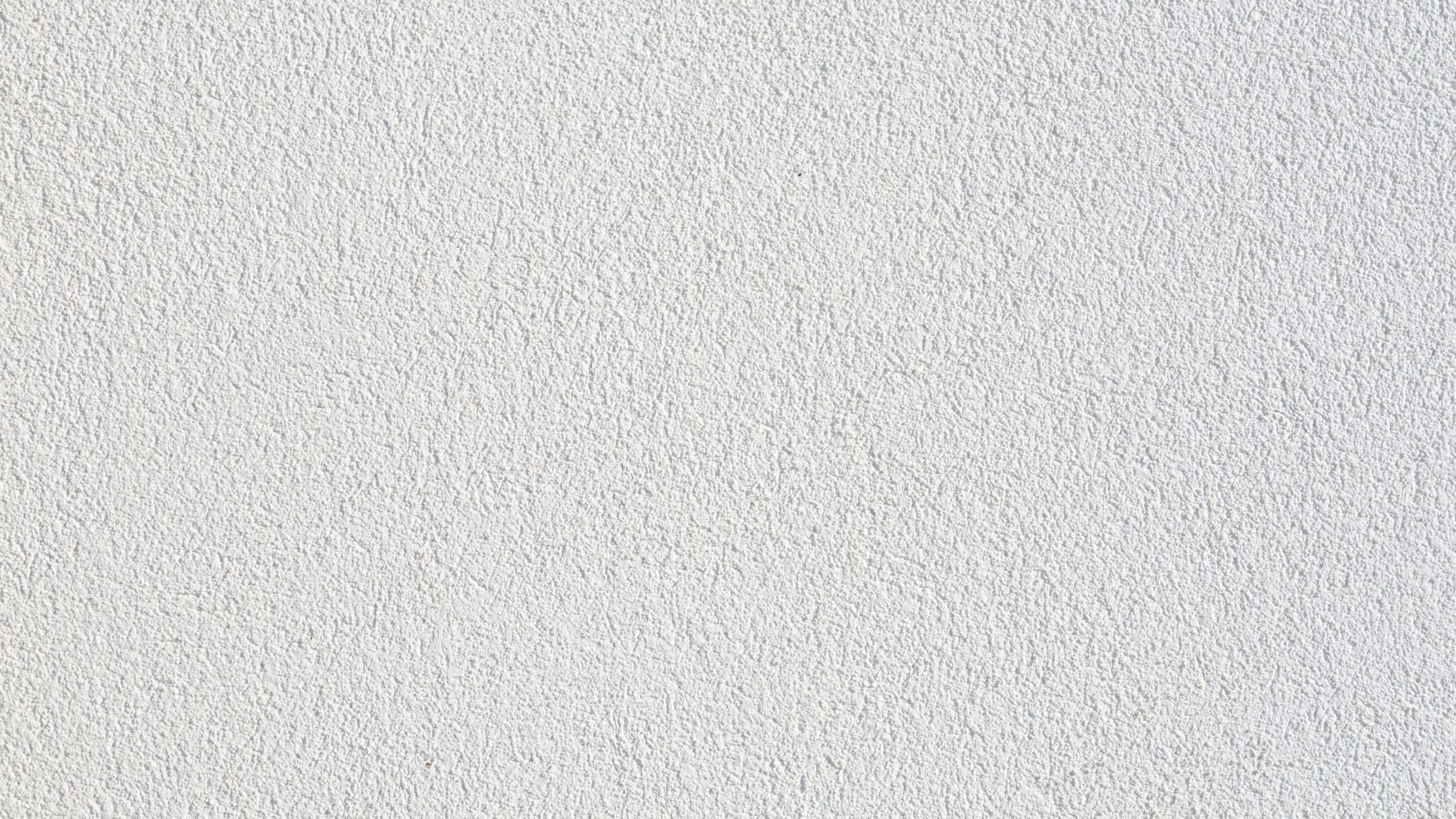 Wall Texture 桌布 壁紙 — 白色平滑灰泥牆的近距離特寫，帶有細微紋理和均勻照明。