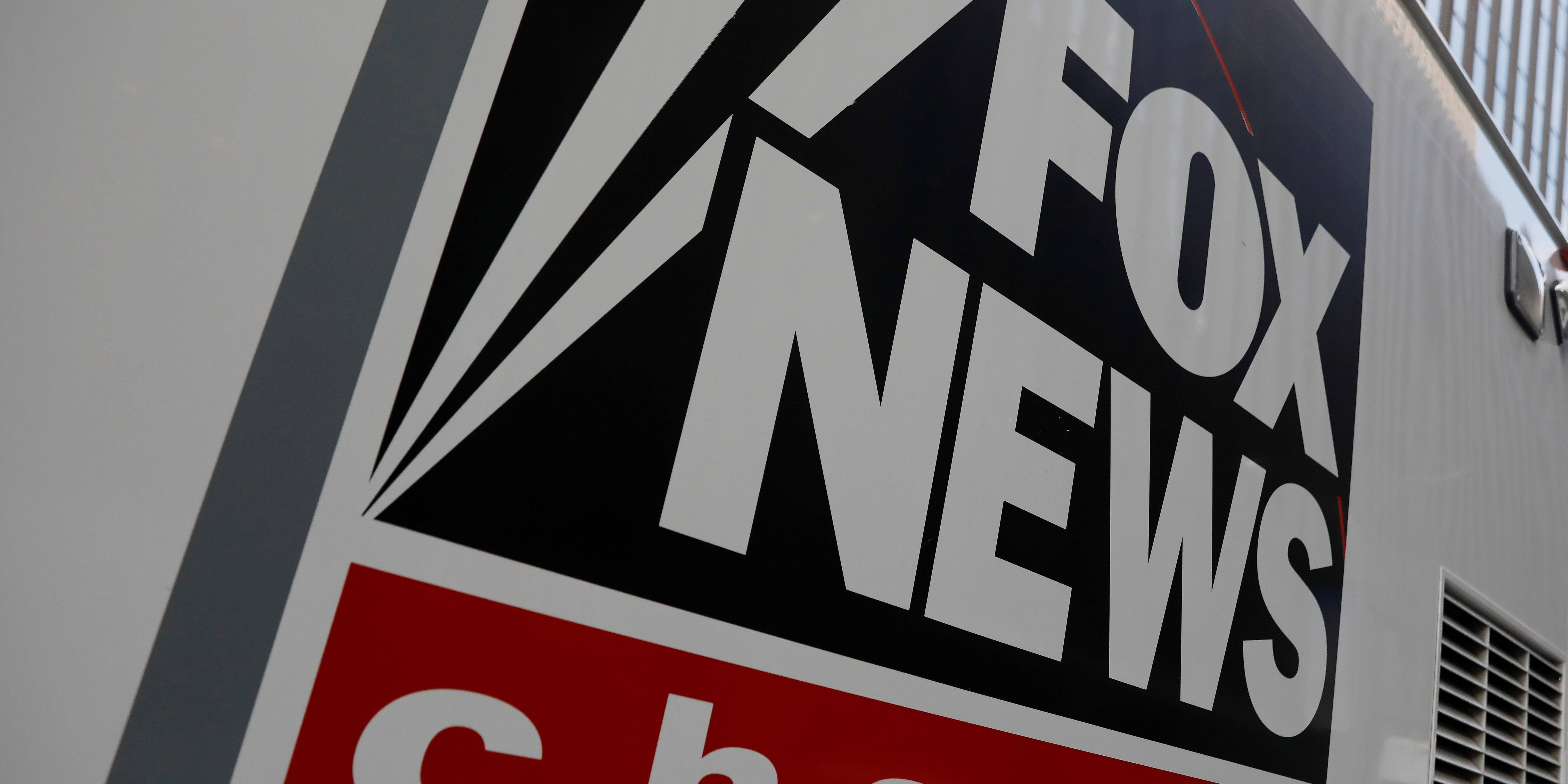 News 桌布 壁紙 — 白色廣播車上Fox News標誌的特寫，帶有醒目的黑、白、紅品牌標識。