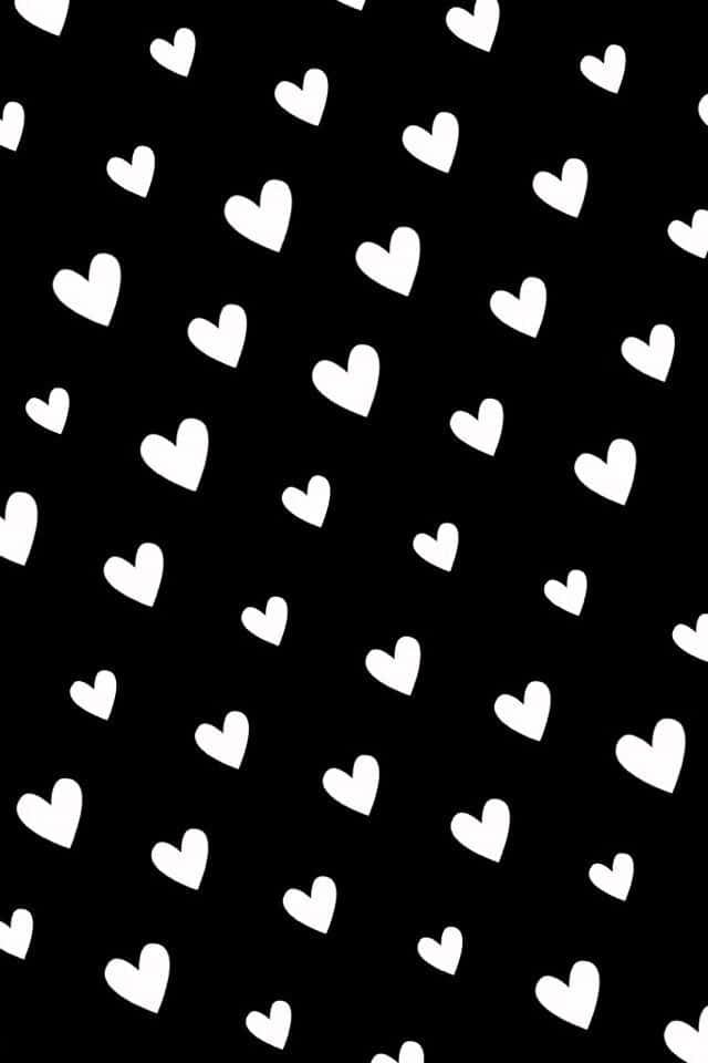 Black And White Heart 桌布 壁紙 — 白色心形以對角線散落在純黑色背景上，形成極簡重複圖案。