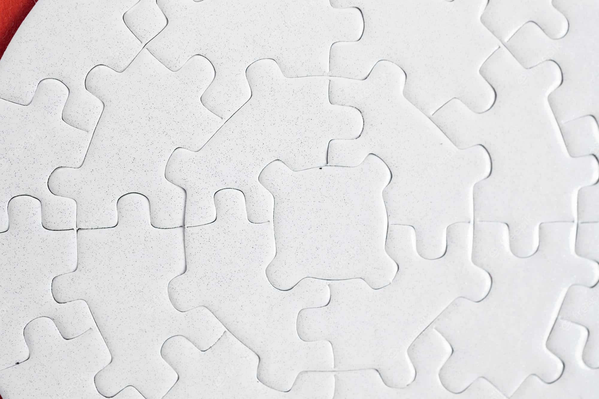 Puzzle 桌布 壁紙 — 白色拼圖塊的特寫，排列成圓形圖案，其中一塊中心拼圖缺失，露出紅色邊緣。