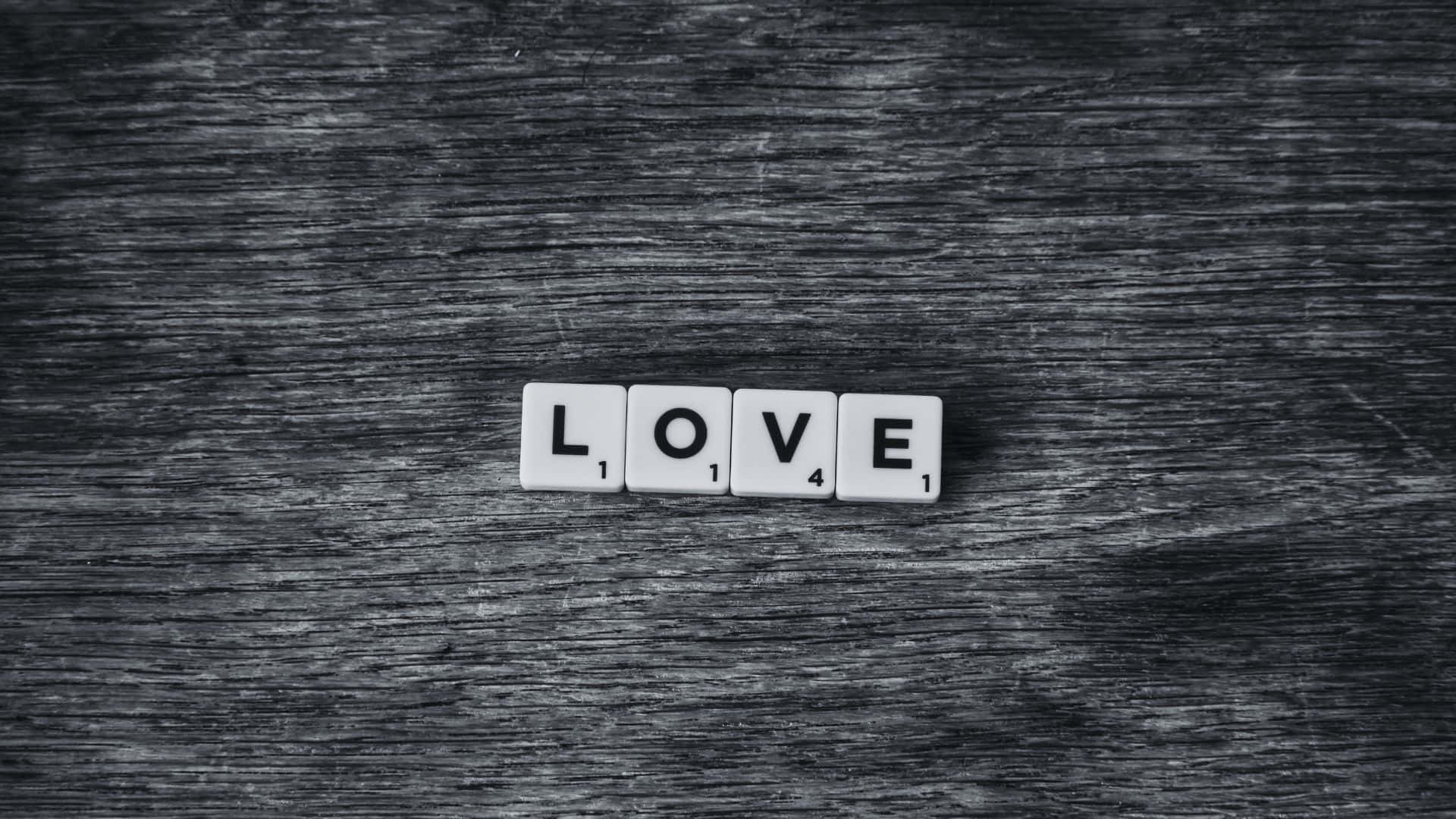 Black And White Word 桌布 壁紙 — 白色拼字磚拼出 love，放置在單色調的深色紋理木質表面上。