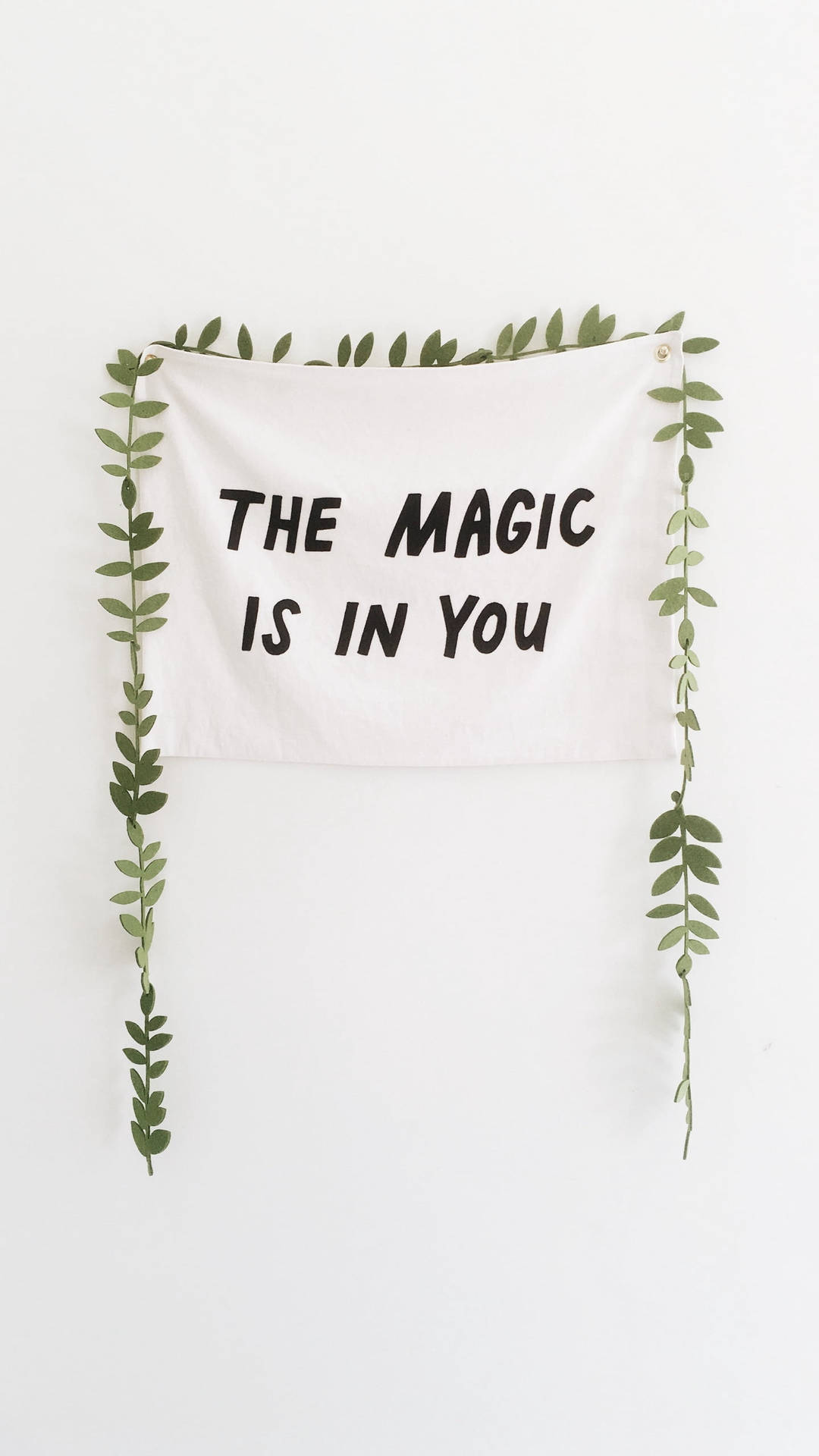 白色掛牆飾物，黑色文字寫著「The Magic Is In You」，由綠色藤蔓框住。 — 美學語錄動圖 壁紙