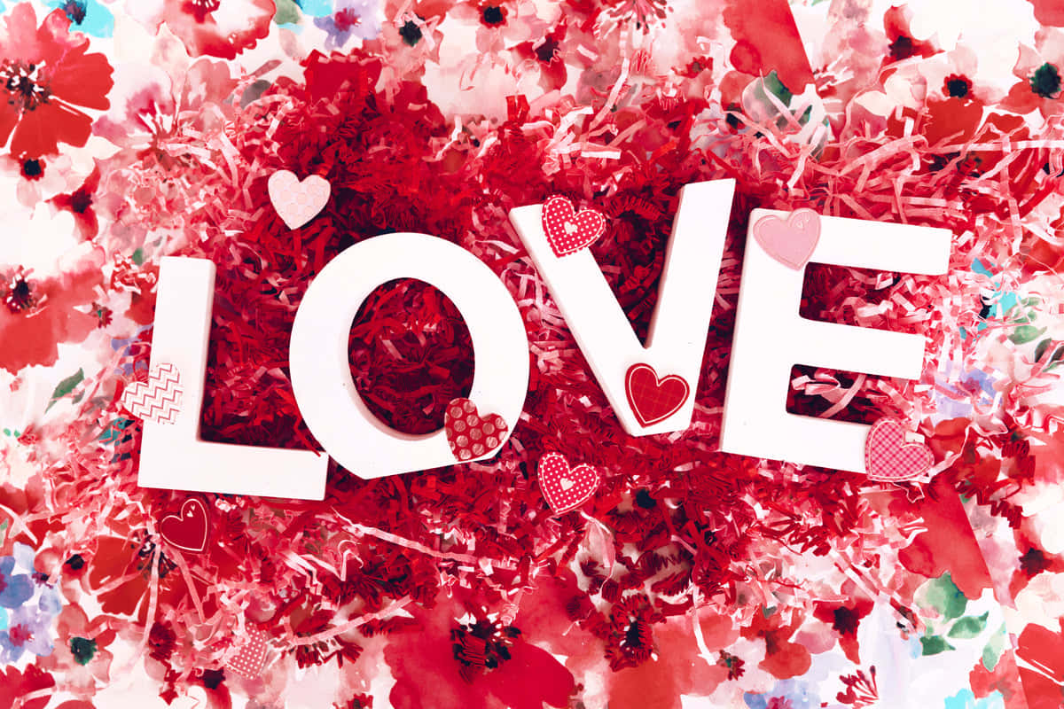 愛心 桌布 壁紙 — 白色方塊字母拼出 LOVE，放置在鮮豔的紅色五彩紙屑和花卉圖案背景上。
